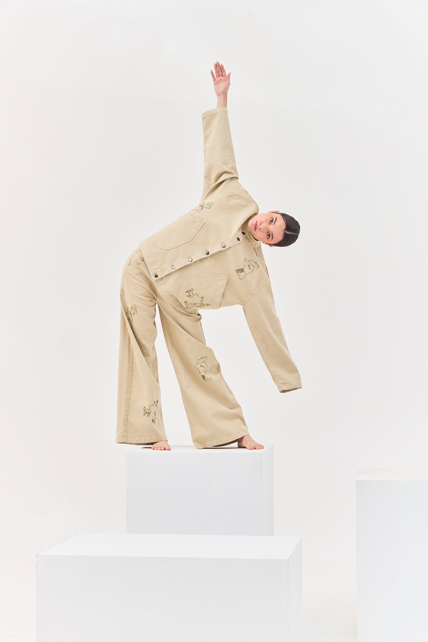 Model wearing the Allpa Mandarin Jacket in Cream with coordinating embroidered trousers in an editorial studio setting.