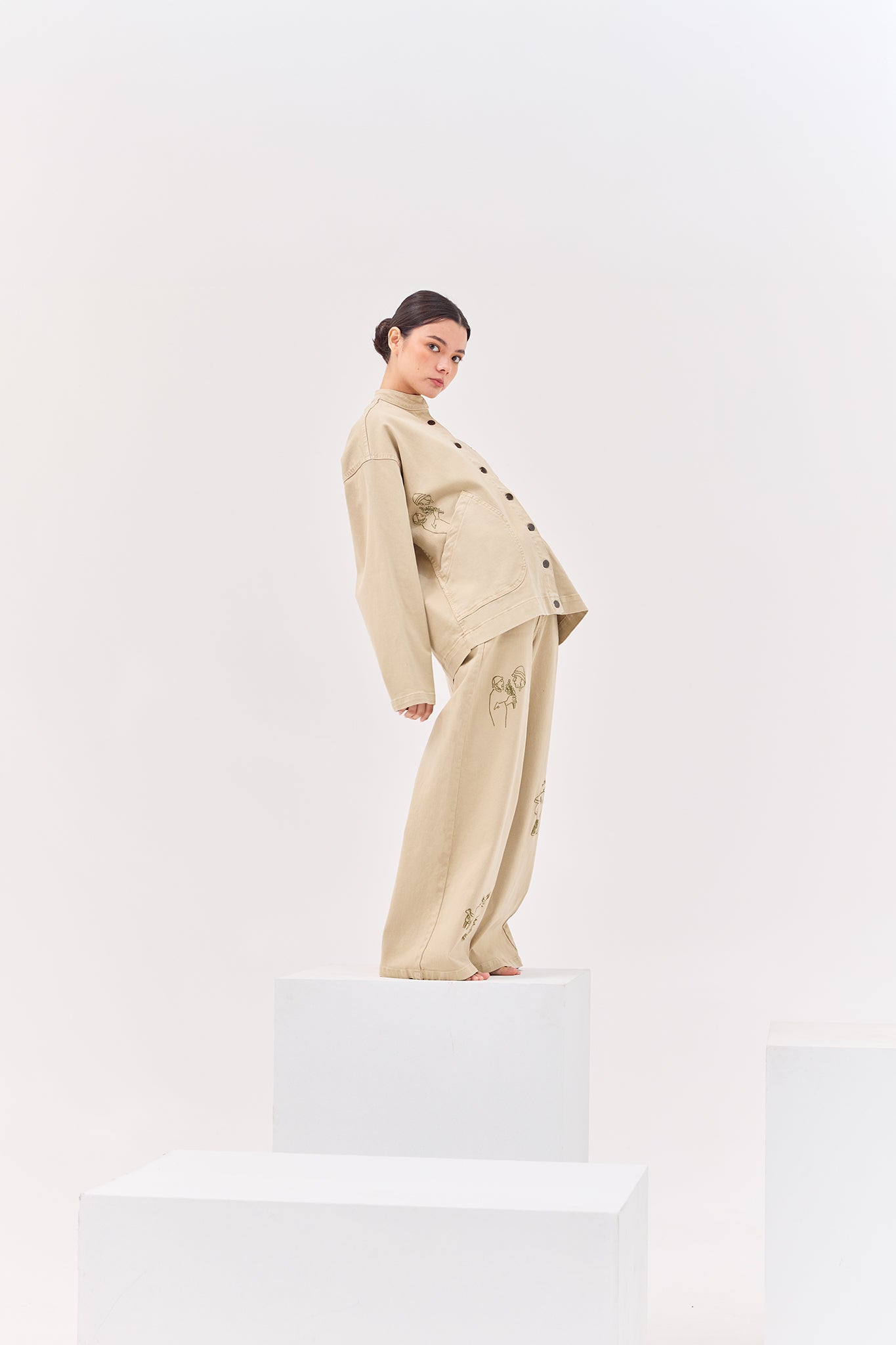 Model wearing the Allpa Cream embroidered wide-leg jeans with the coordinating Allpa Mandarin Jacket in a contemporary studio setting.