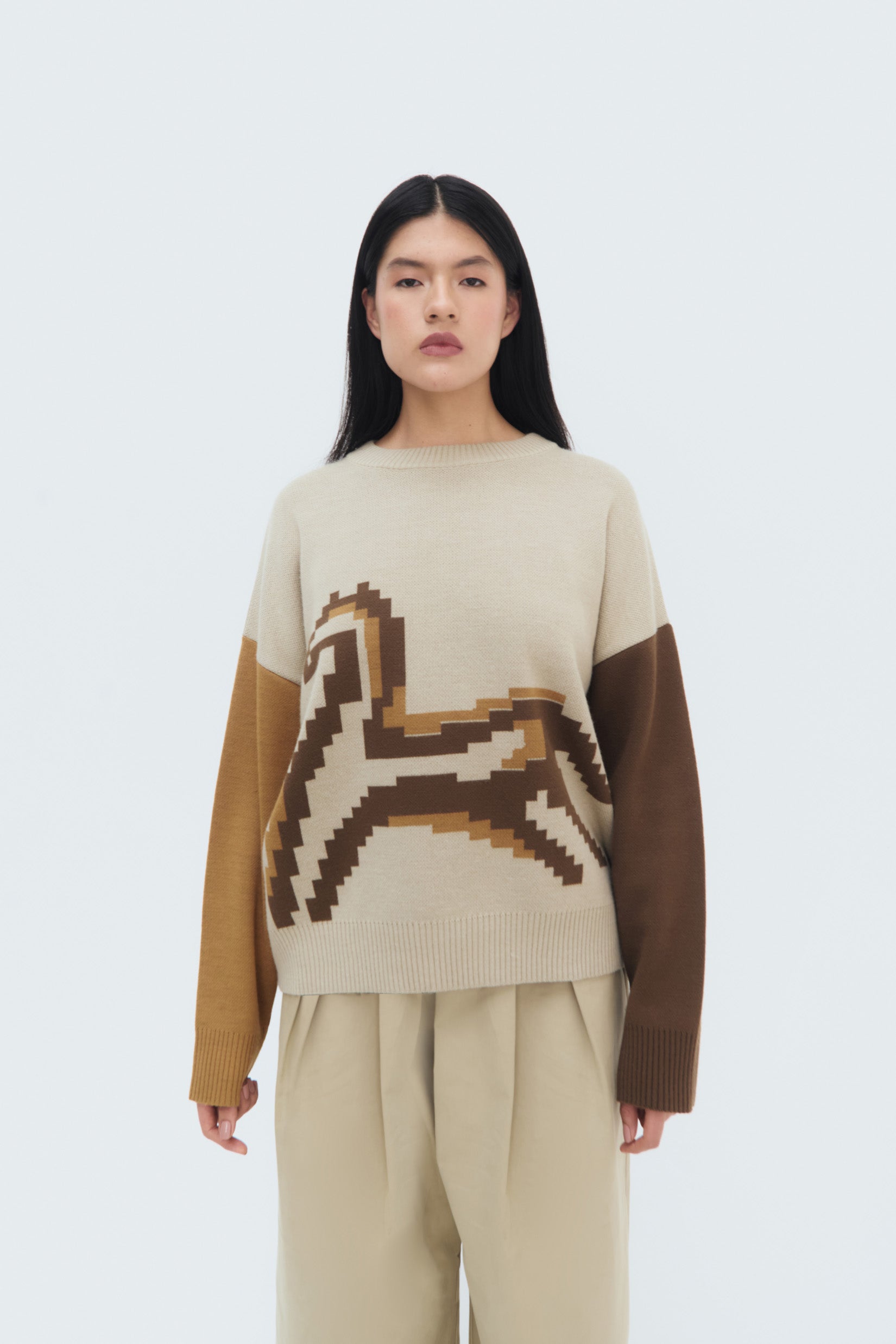 Model wearing the Caballito Sweater – beige and brown geometric horse motif