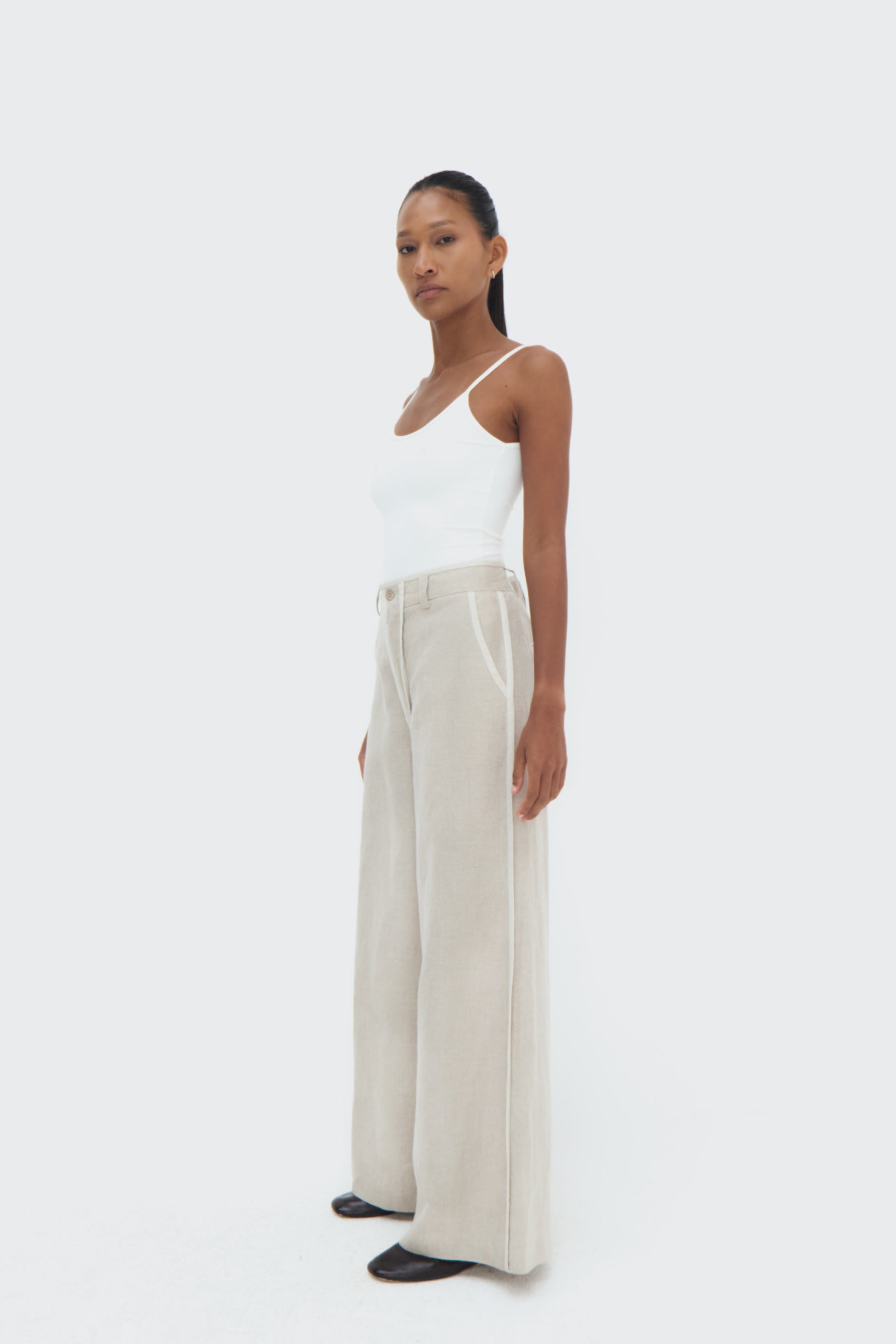 Side view of Duna Pipped Trousers – tailored waistband and relaxed silhouette