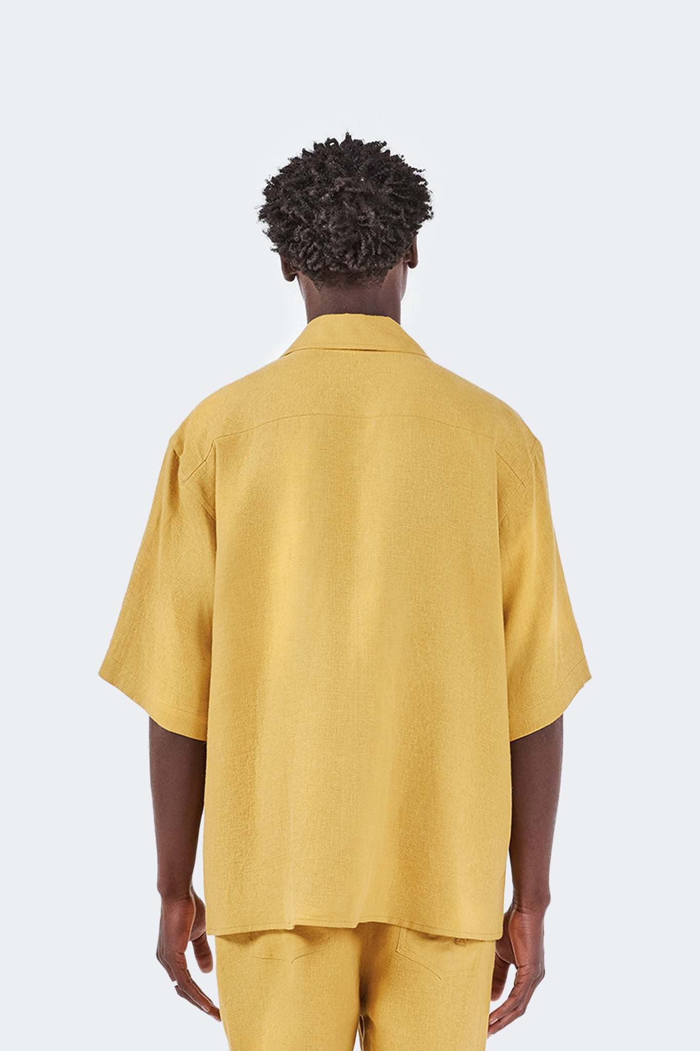 Close-up back view of the Floreana Short-Sleeved Shirt in Mustard highlighting the natural 100% linen texture, back yoke, and relaxed fit.