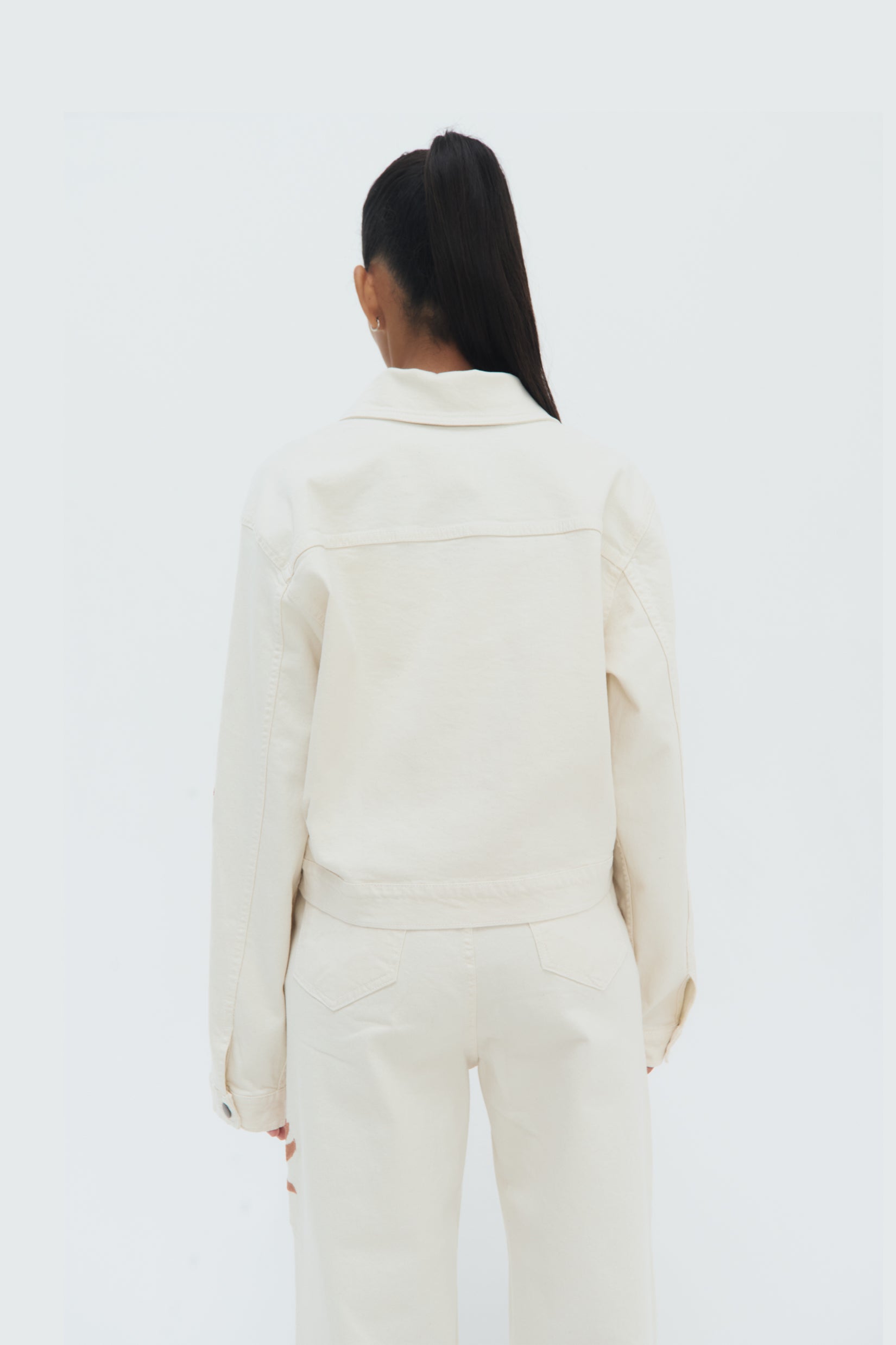 Back view of Iconos Cropped Jacket – structured silhouette and embroidery details