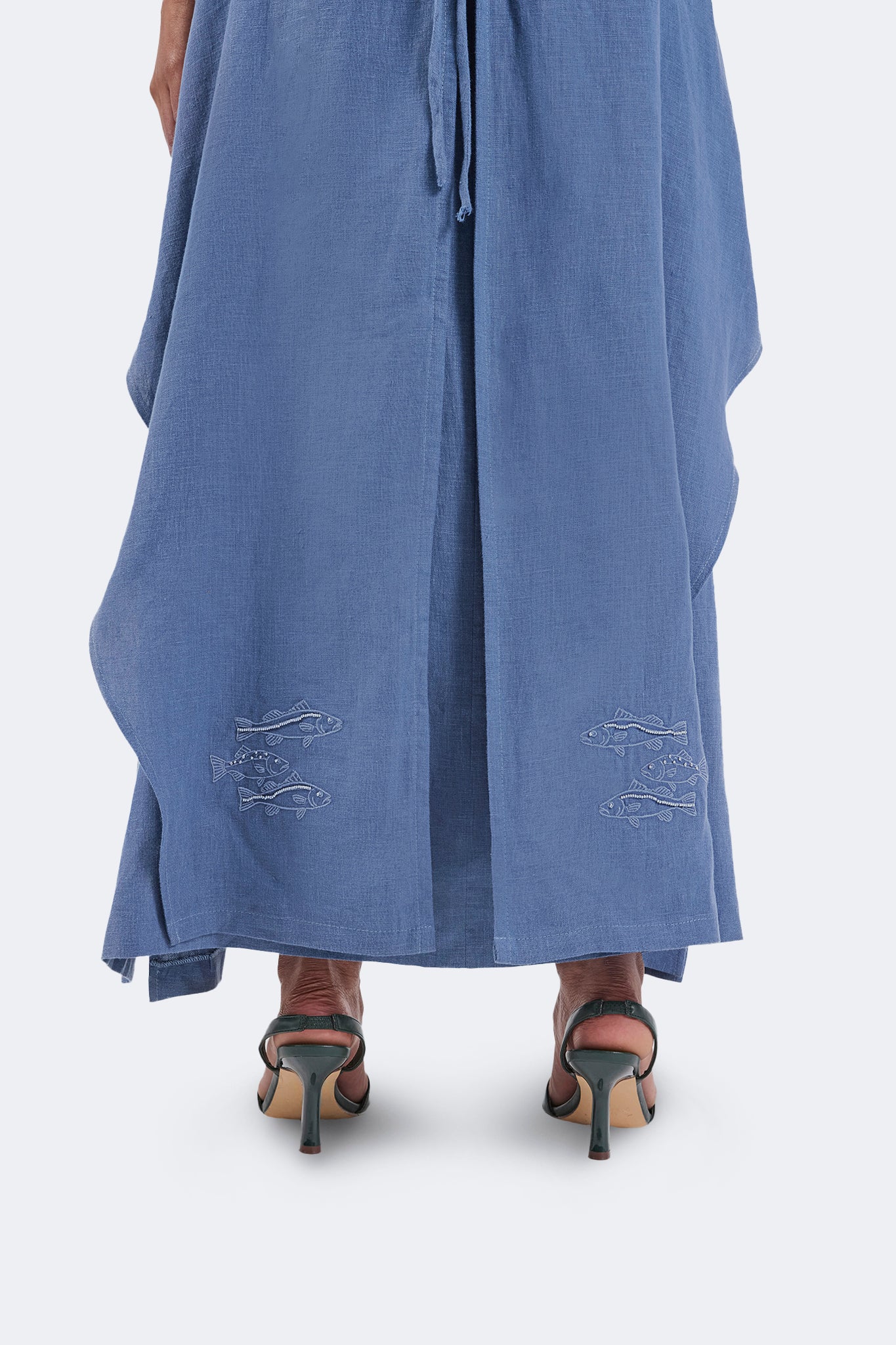 Close-up of the Jama Halter Dress showcasing embroidered fish motifs, flowing linen construction, and the elegant full-length silhouette.