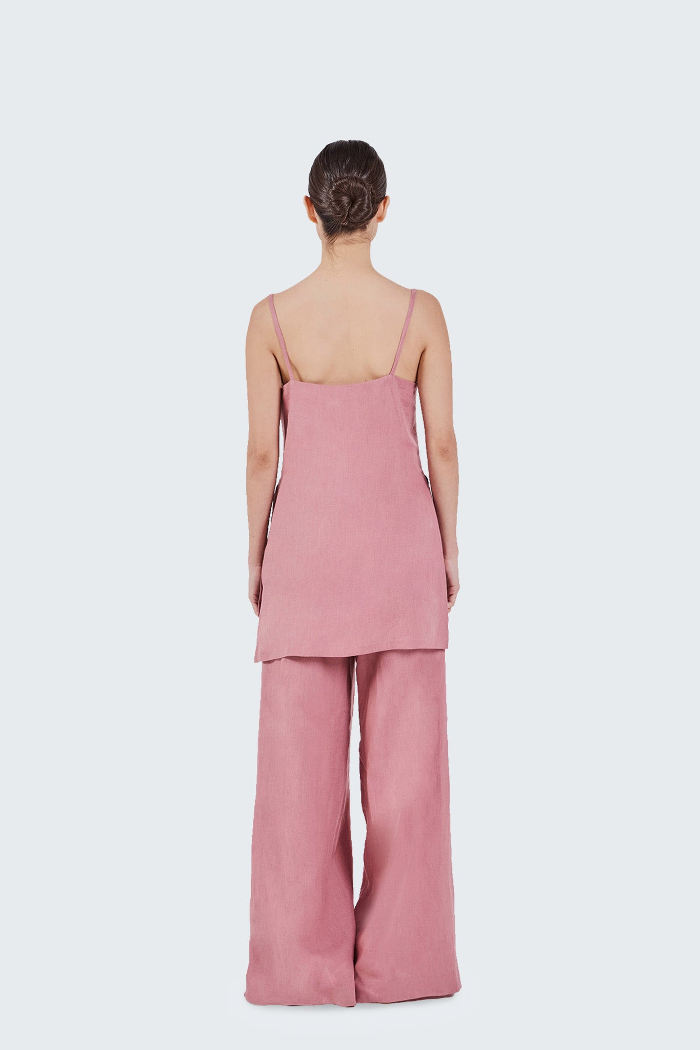 Person wearing a pink outfit on a white background