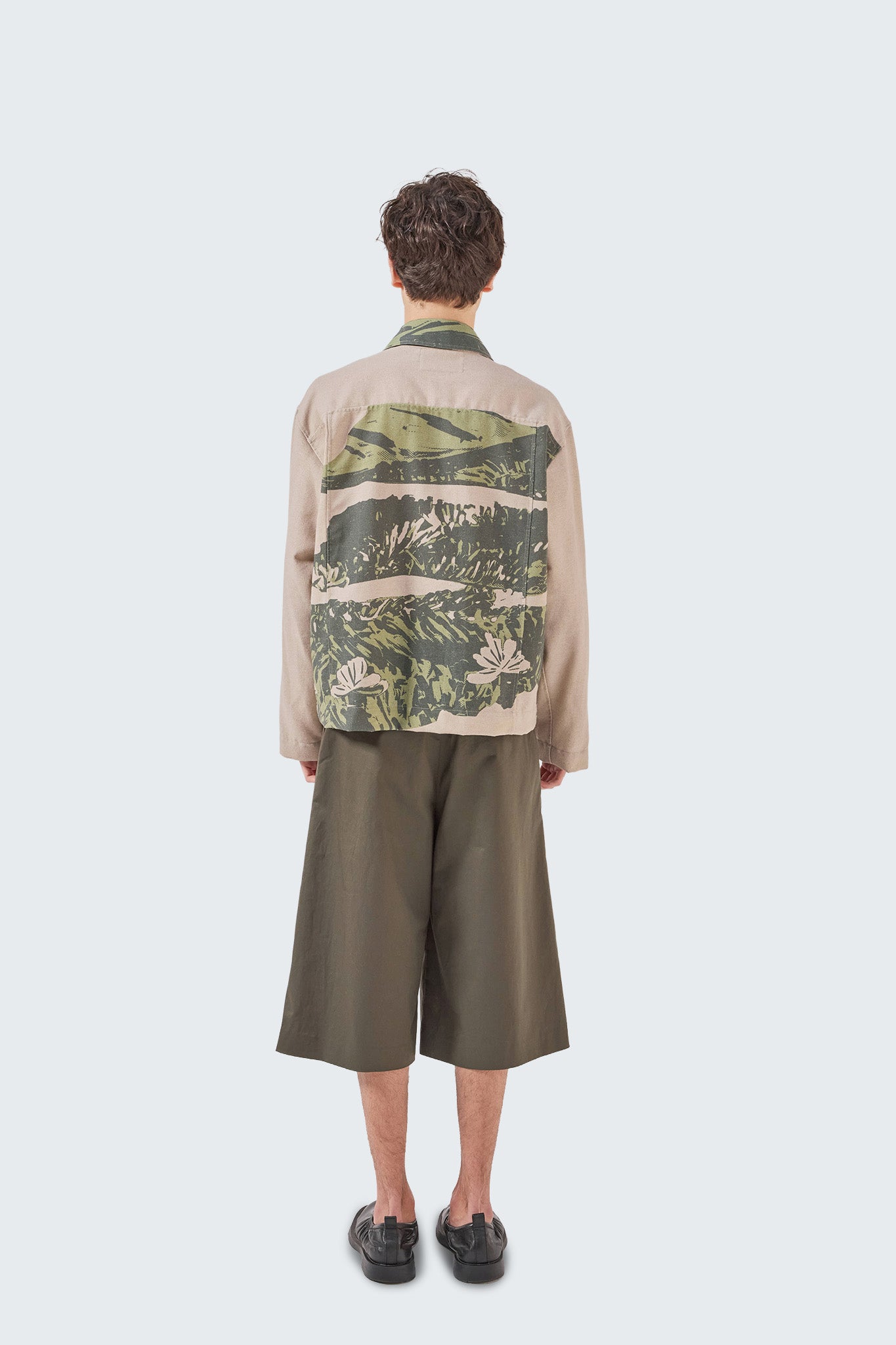 Back view of the Kikuyo Workman Jacket featuring continuous moss and beige landscape print on lightweight linen fabric.