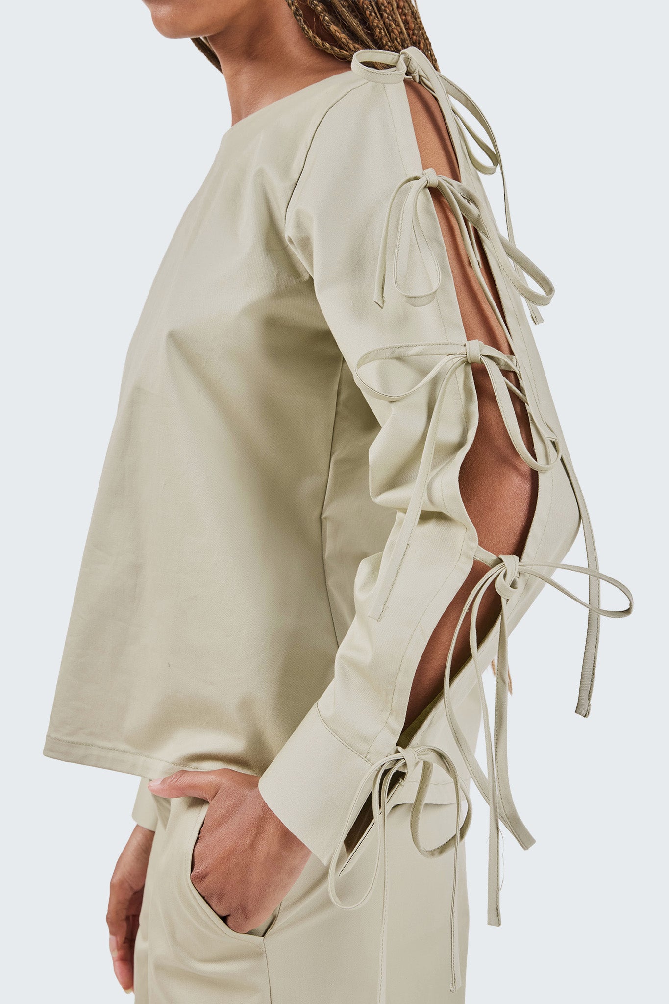 Beige outfit with lace-up sleeves on a white background