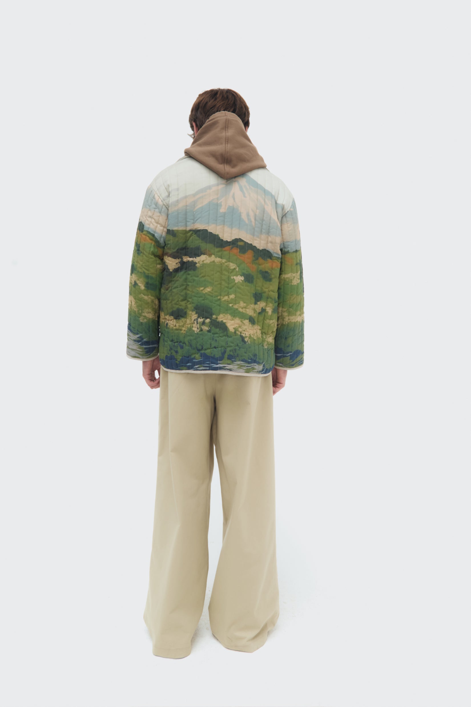 Male model back view of the Bruma Utility Jacket by Olga Fisch featuring an abstract landscape print
