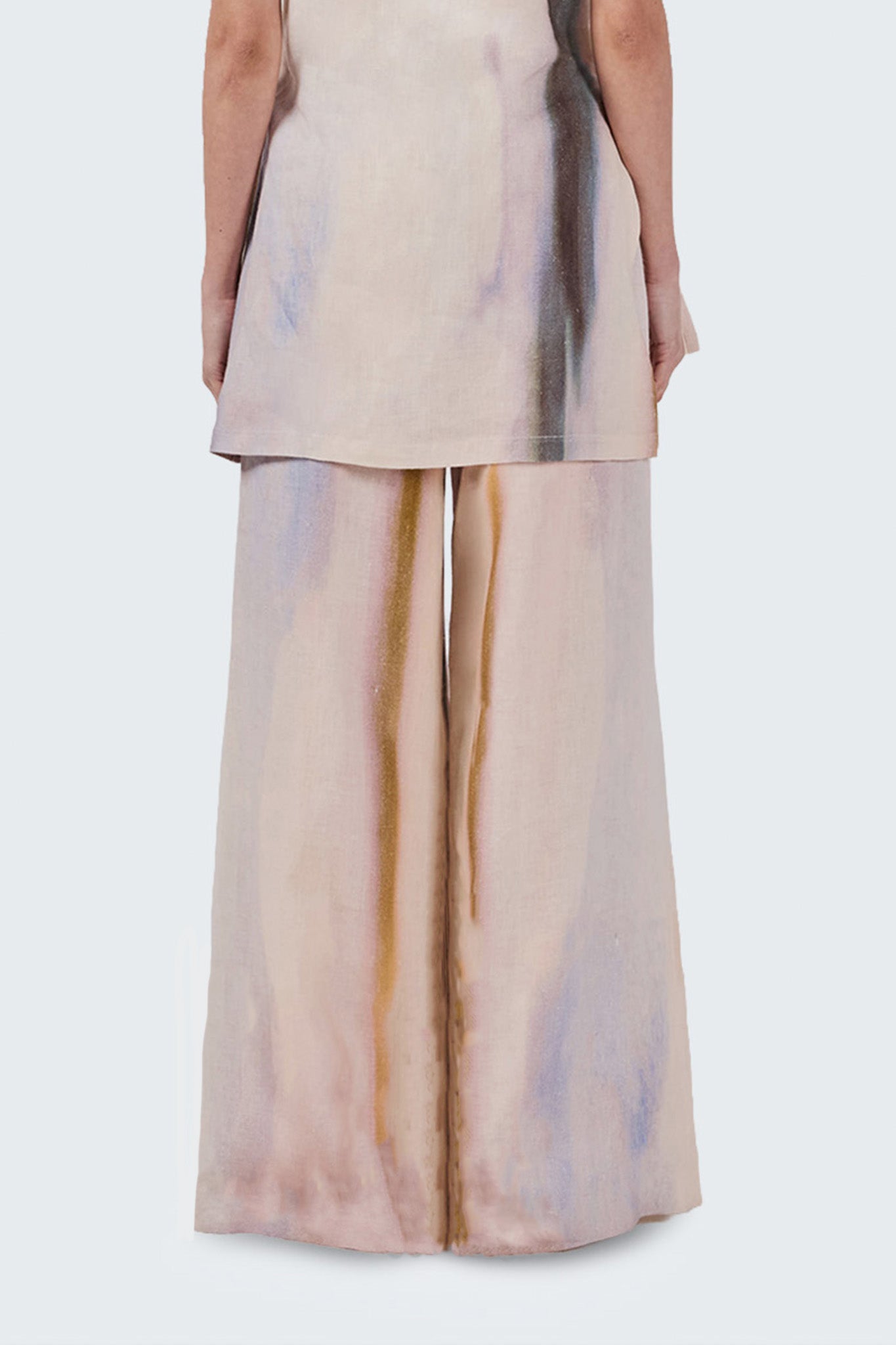 Beige and brown tie-dye pants worn by a person on a white background