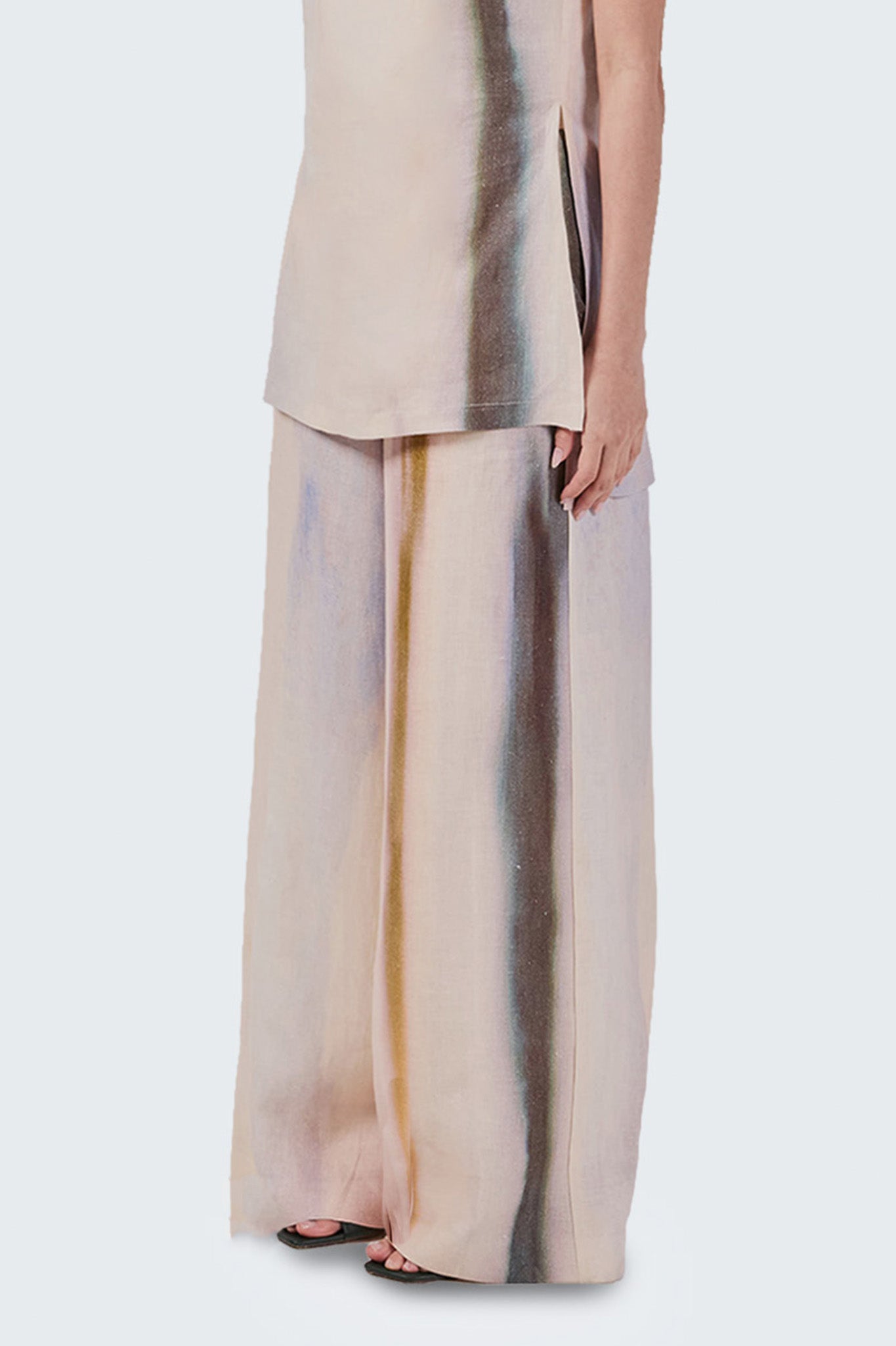Beige outfit with a long, sheer skirt featuring vertical stripes on a white background