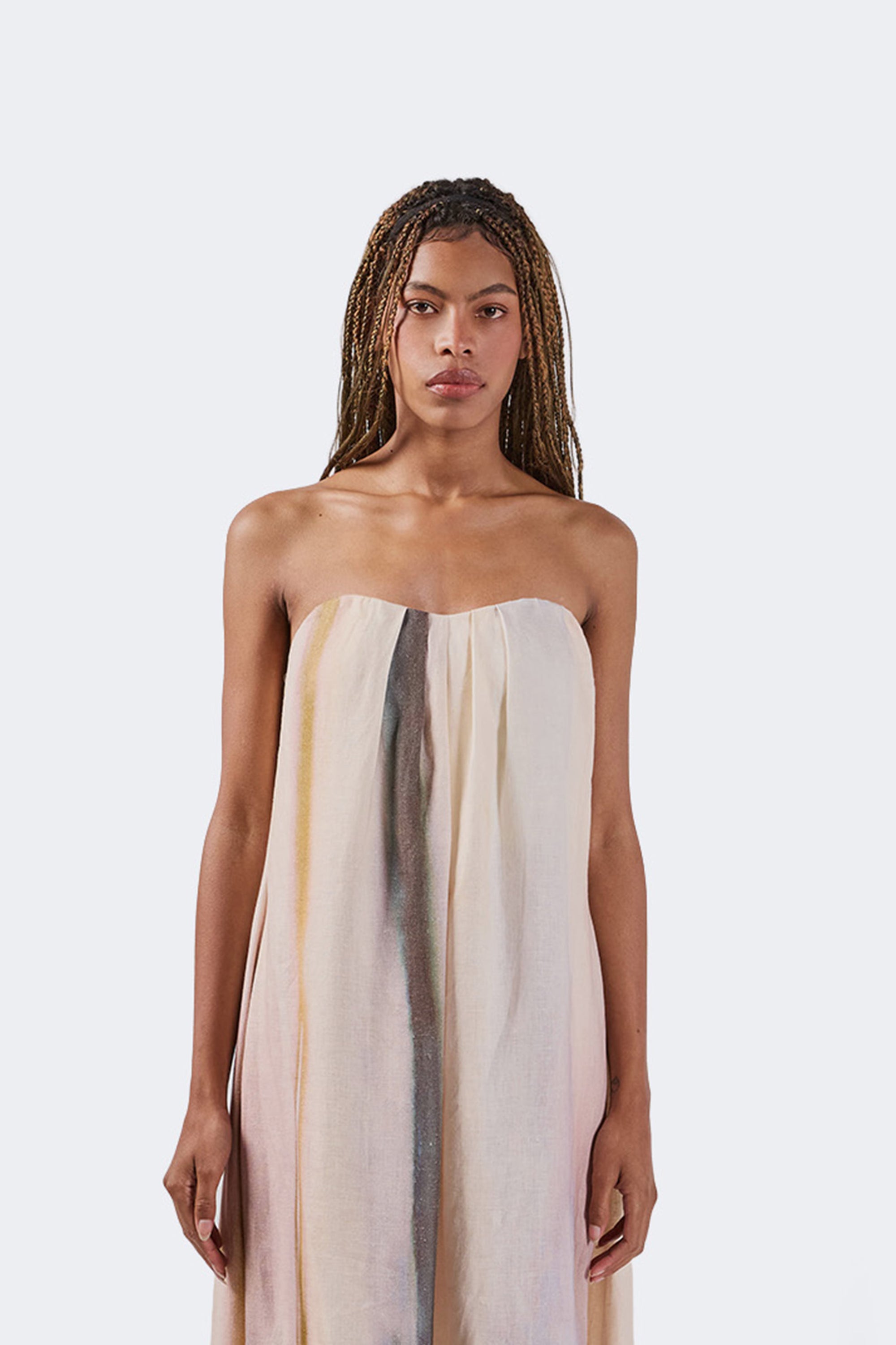 Woman wearing a strapless dress with gradient colors on a white background