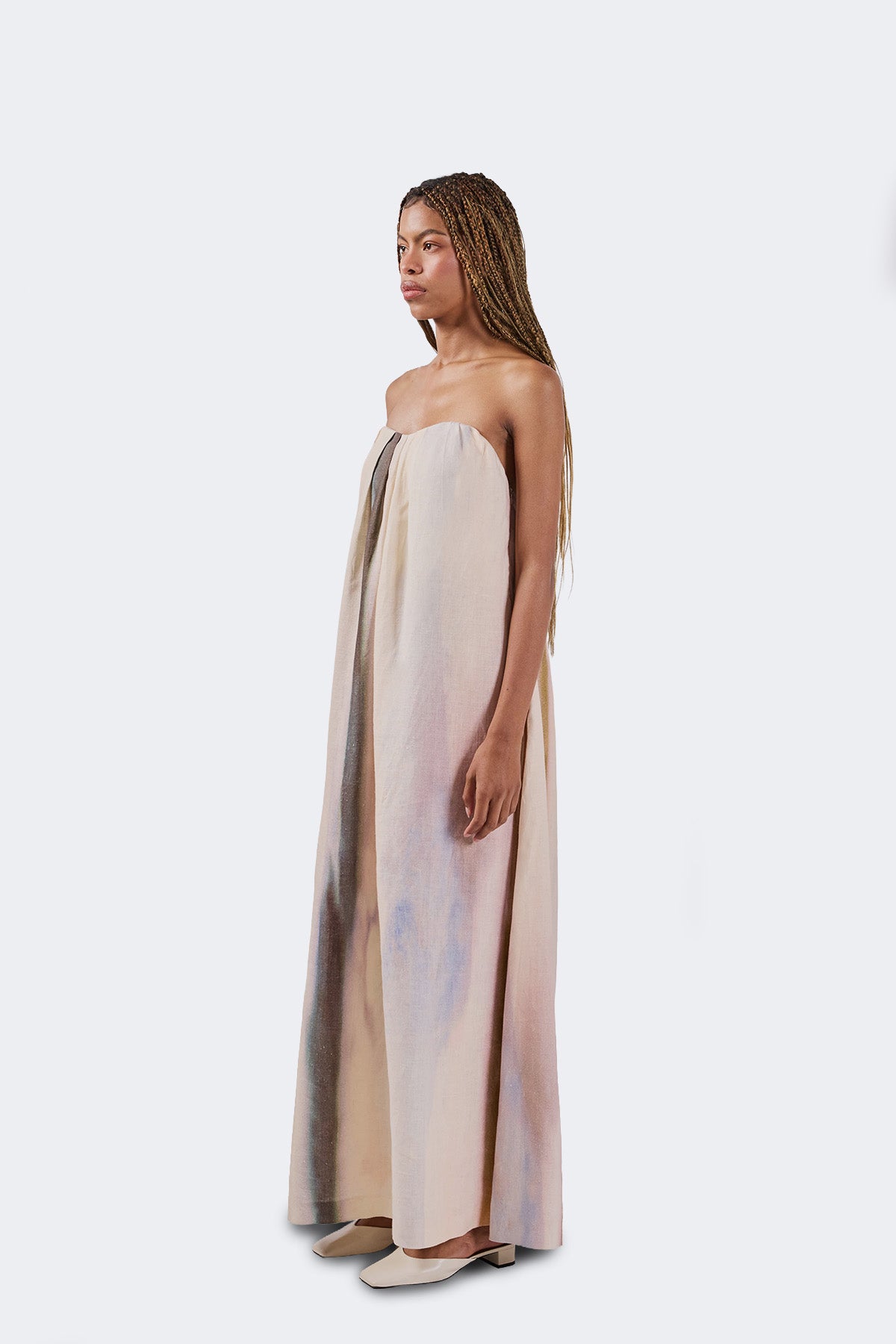Woman wearing a strapless dress with a gradient design on a white background