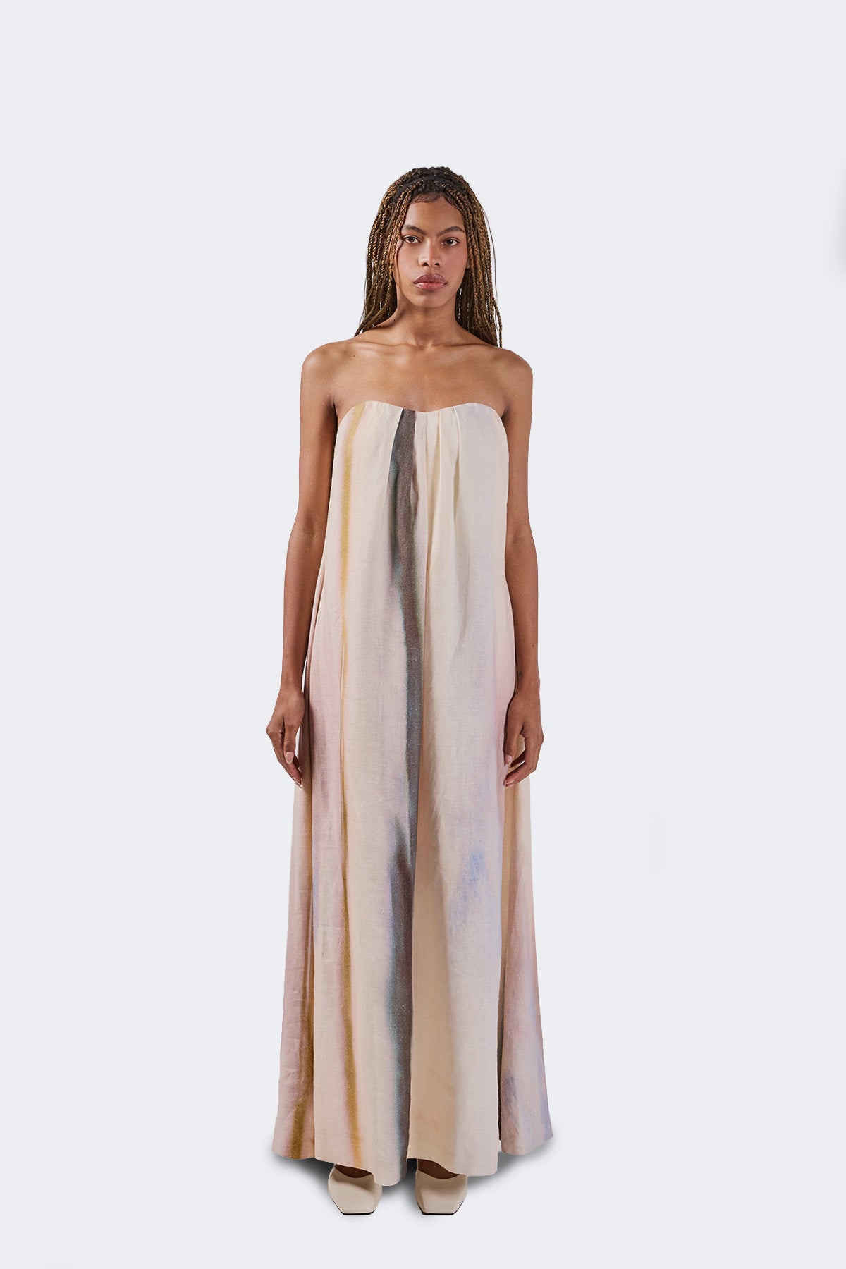 Woman wearing a strapless dress with a gradient design on a white background