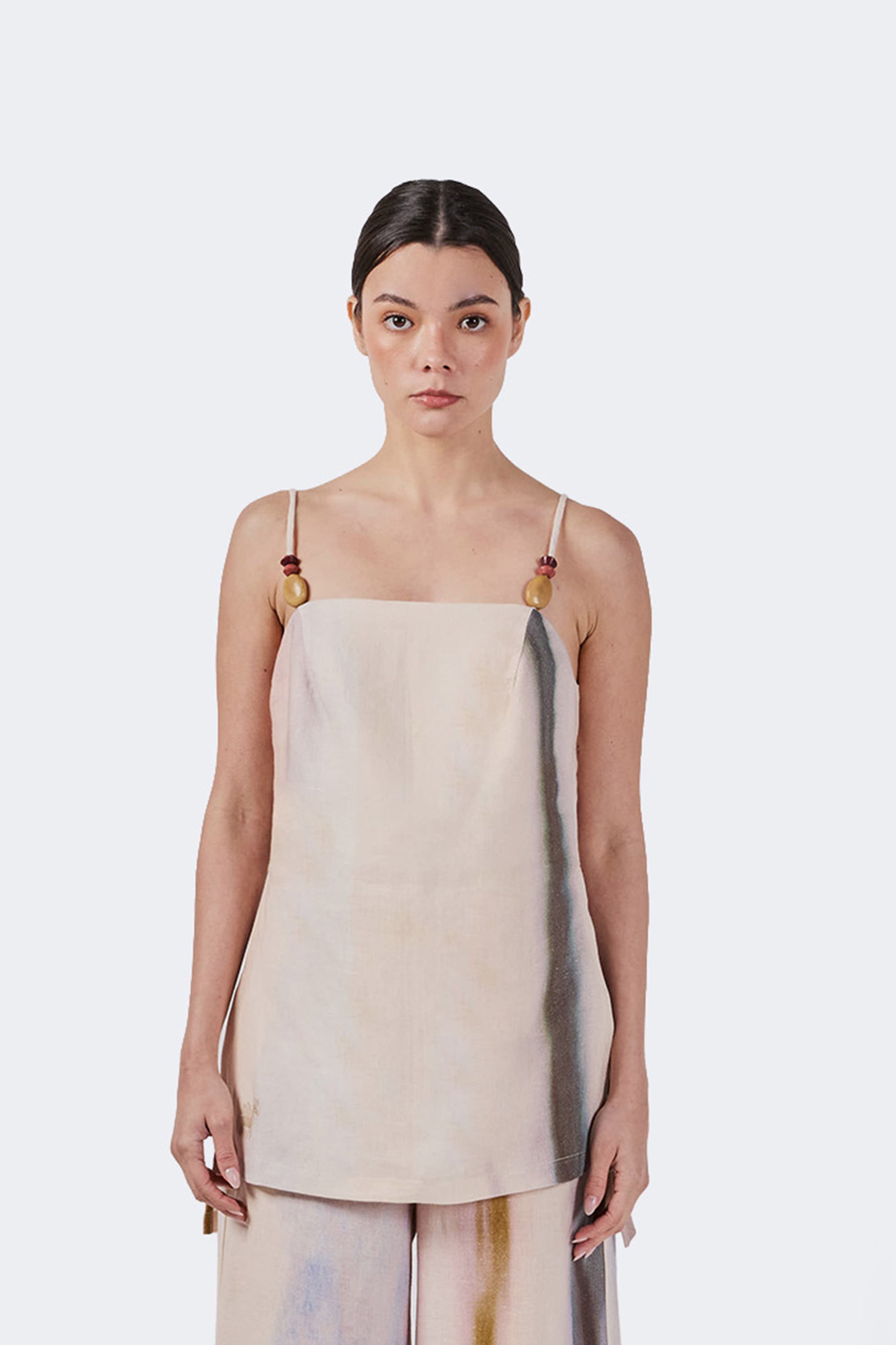 Woman wearing a strapped linen top with tagua detail.