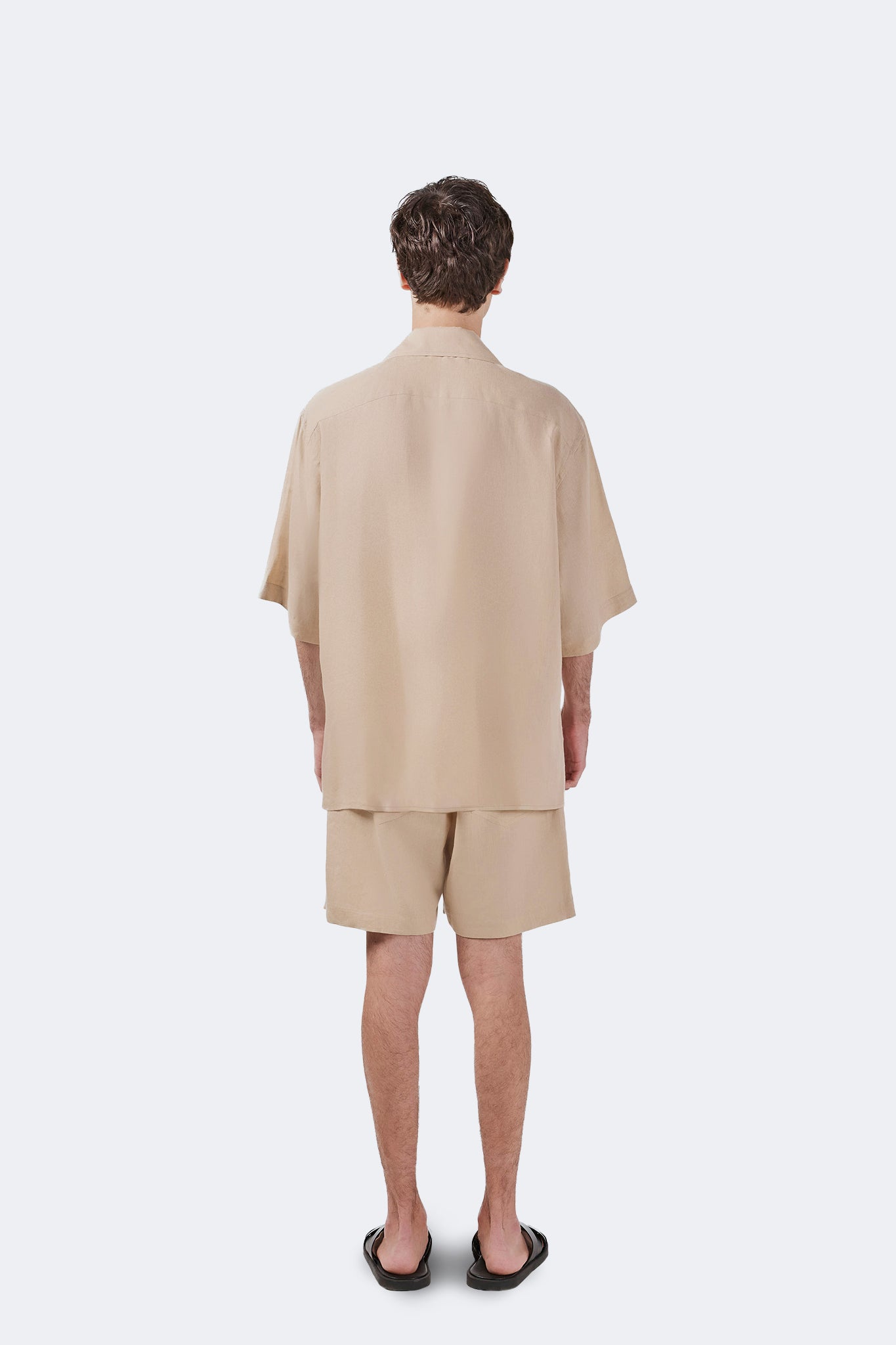 Back view of the Palmira Linen Shorts Ivory with a relaxed mid-length silhouette and minimalist design.