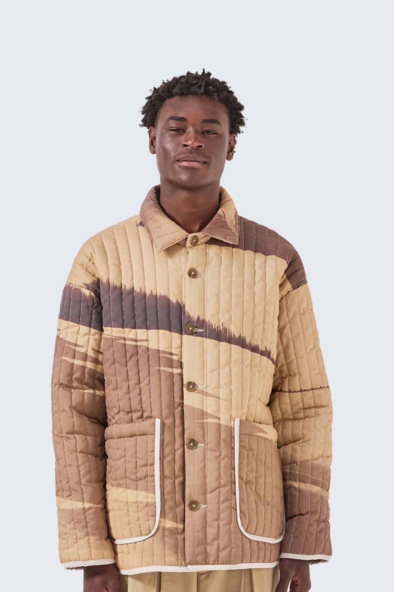 Close-up of the Palmira Quilted Jacket showcasing vertical quilting, button-front closure, and exclusive Palmira artwork.