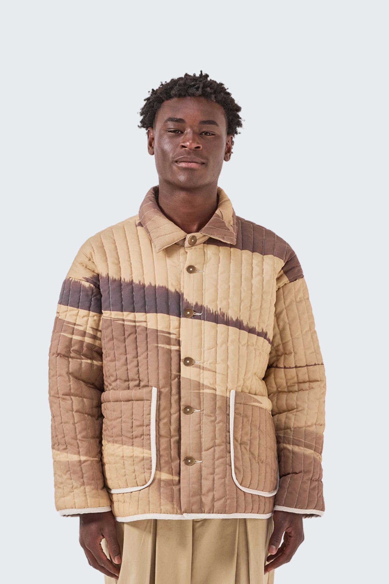 Close-up of the Palmira Quilted Jacket showcasing vertical quilting, button-front closure, and exclusive Palmira artwork.