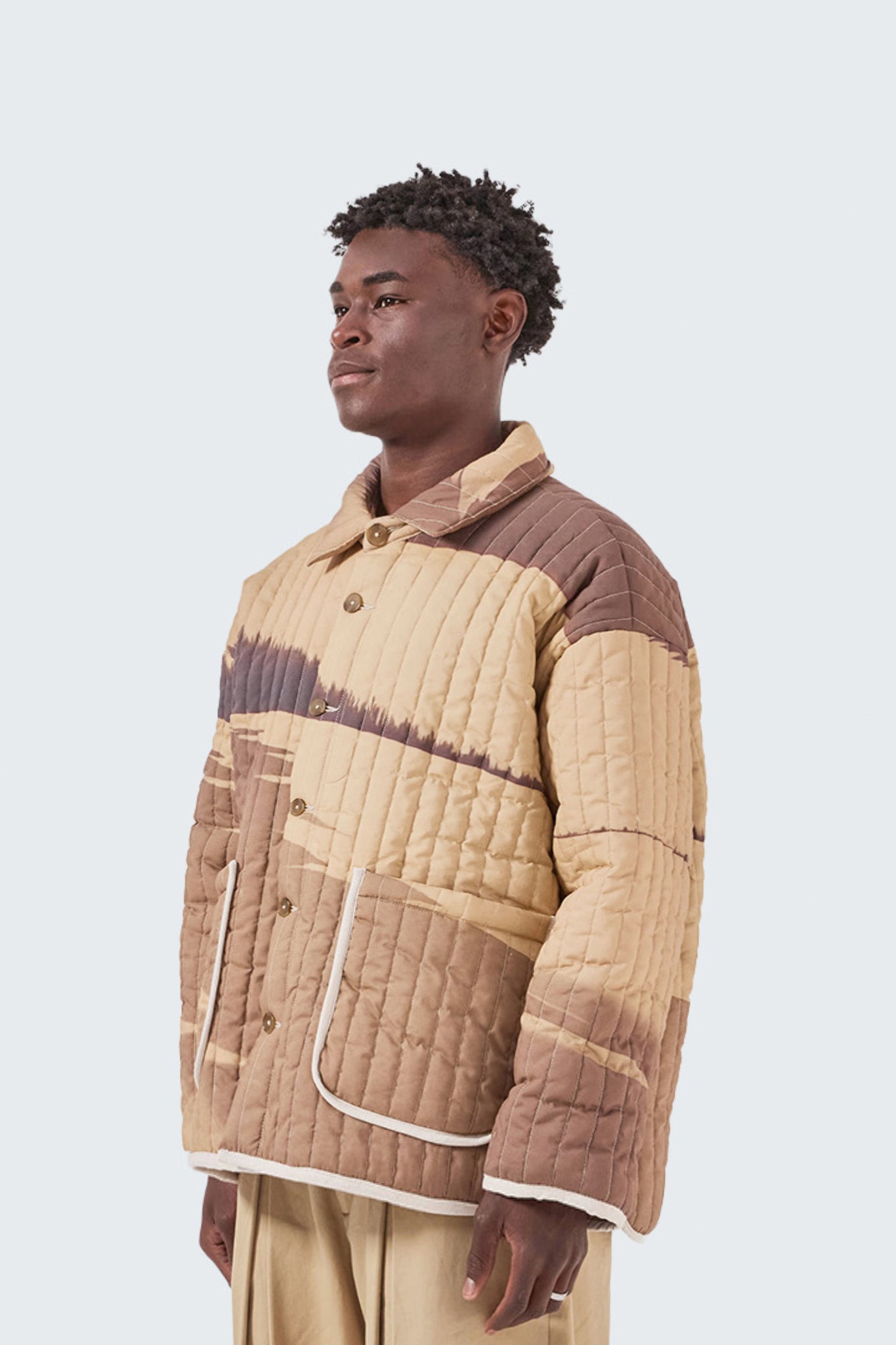 Detailed side profile of the Palmira Quilted Jacket with contrast piping and archive-inspired abstract print.