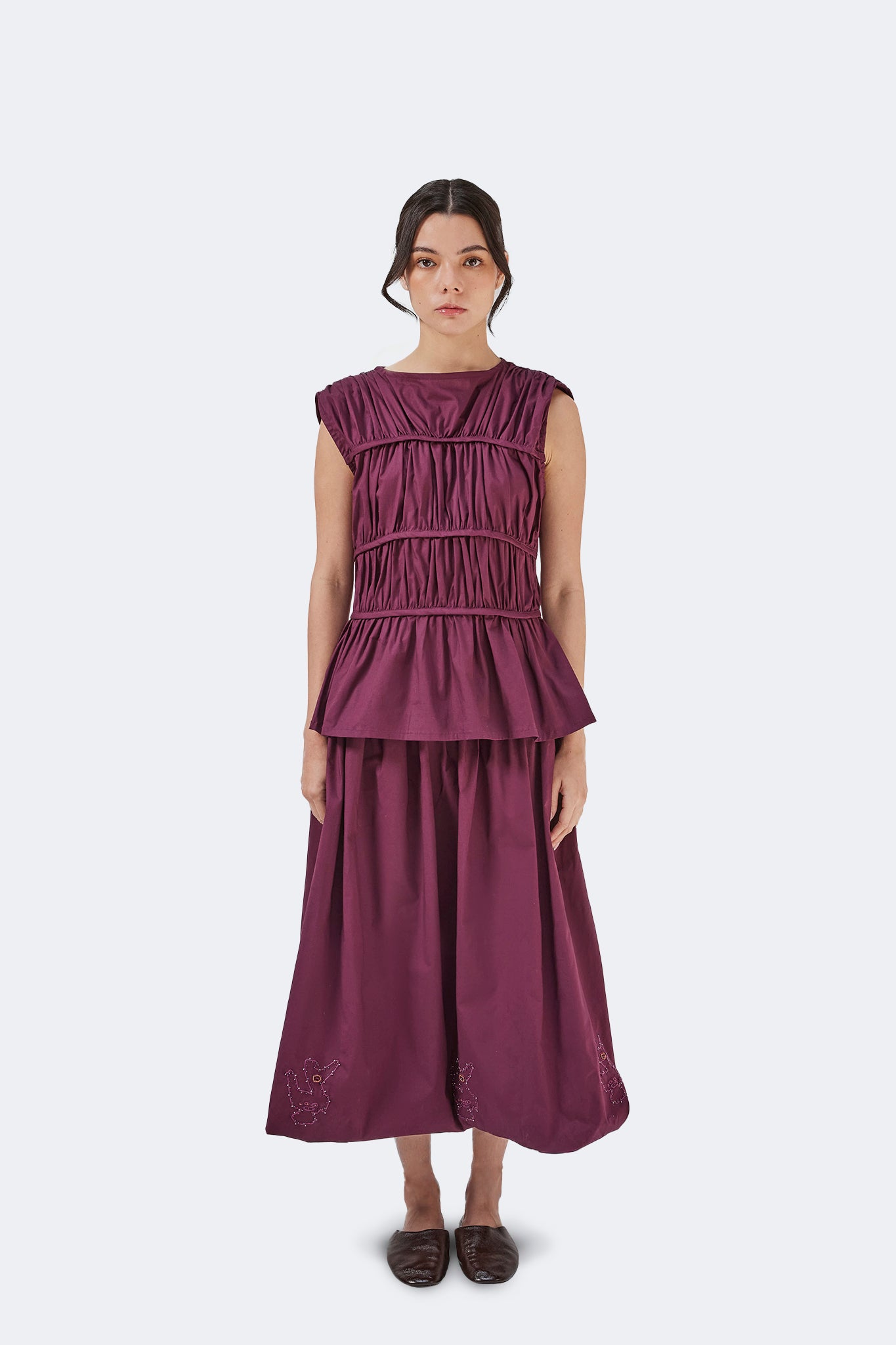 Front portrait of the Palo Santo Gathered Blouse in Grape highlighting the gathered bodice, clean bateau neckline, and softly extended cap sleeves.