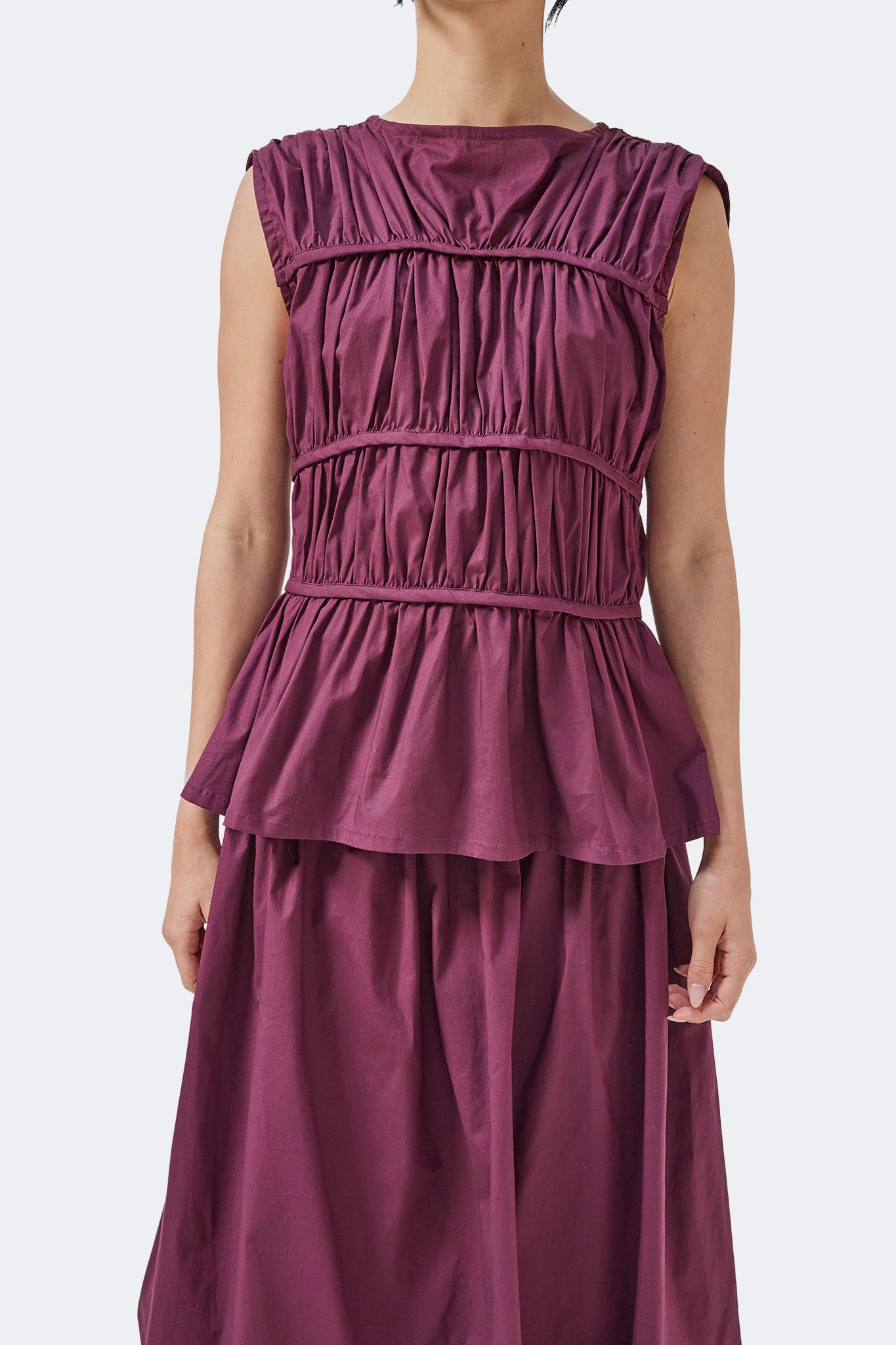 Front detail of the Palo Santo Gathered Blouse in Grape crafted from a cotton blend with sculptural gathered bodice, bateau neckline, and peplum silhouette.