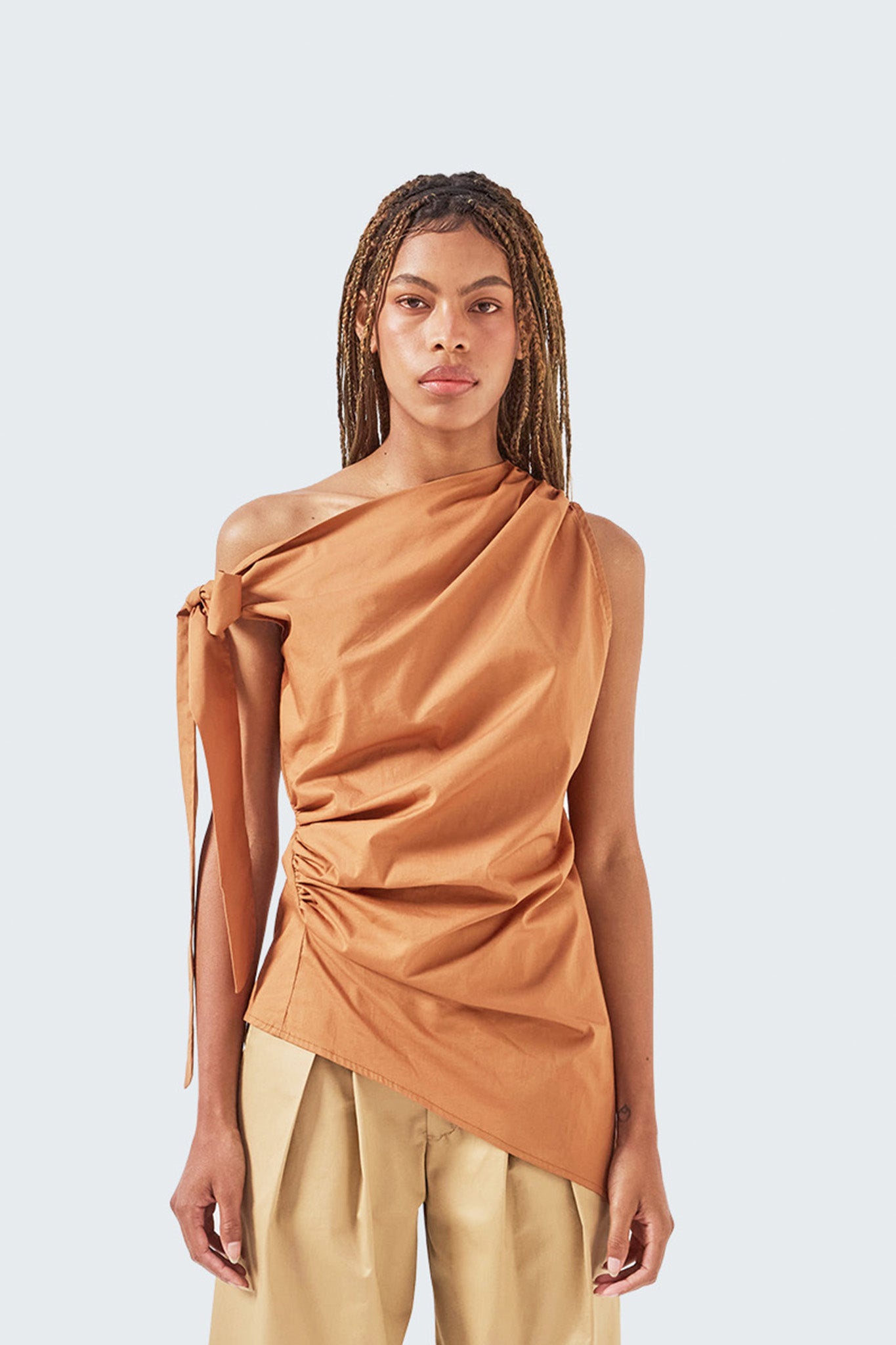 Close-up of the Pambil One-Shoulder Knotted Top highlighting asymmetric neckline, gathered waist, and knot detail.