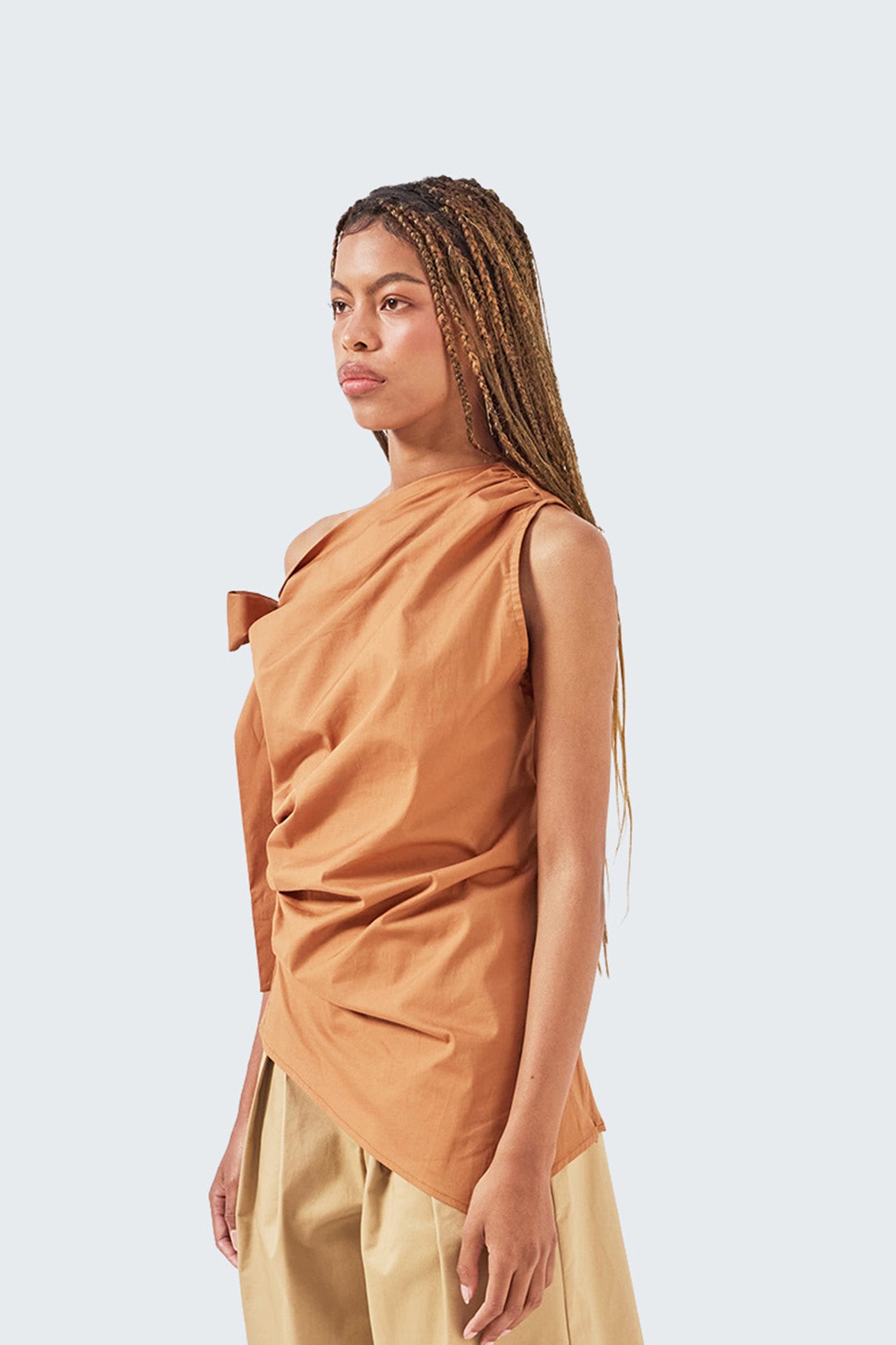 Close-up side view of the Brick one-shoulder top featuring gathered draping and architectural construction.