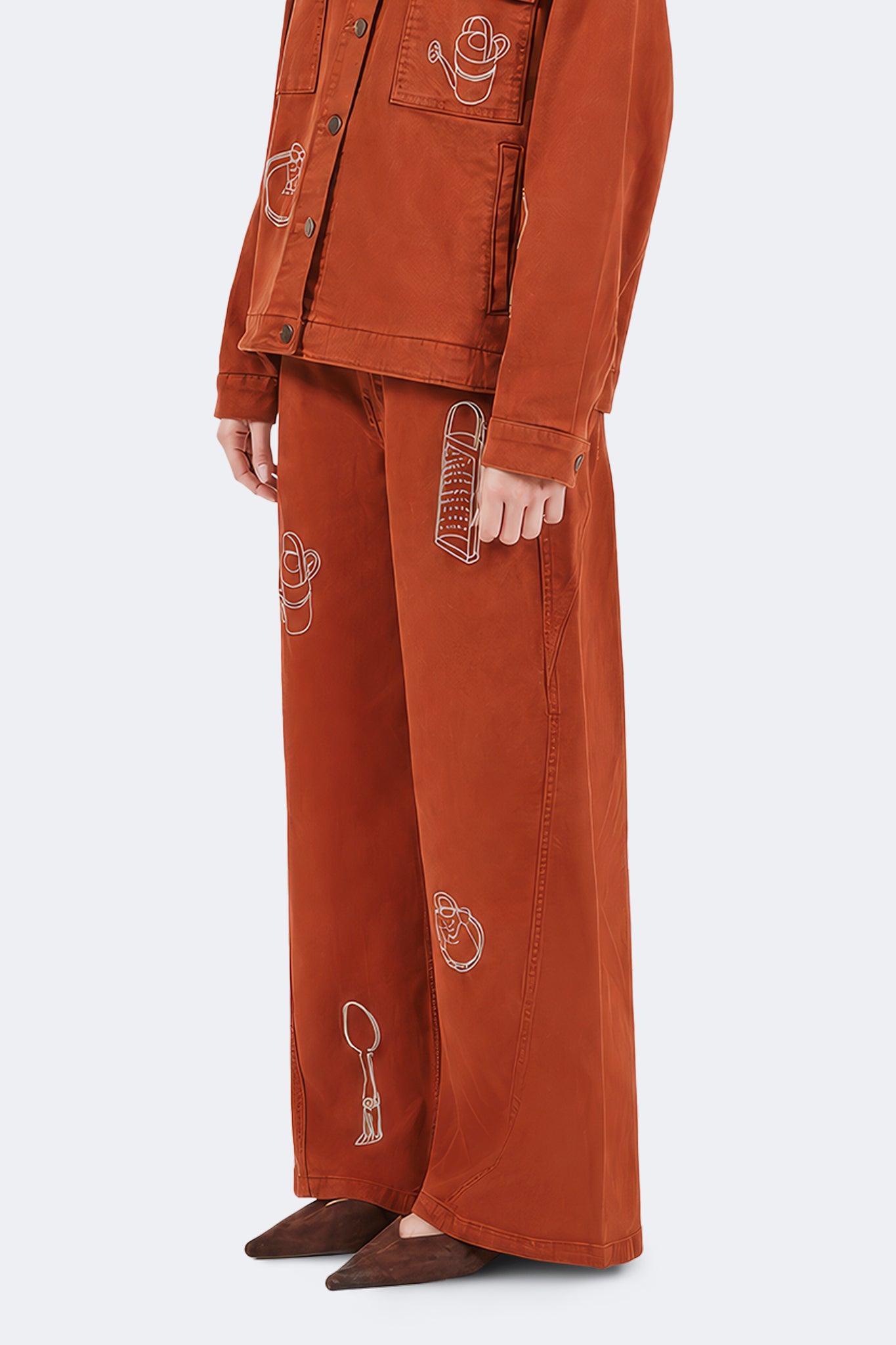 Side detail of Payla Jeans in Brick highlighting embroidered archive motifs and wide-leg denim construction.