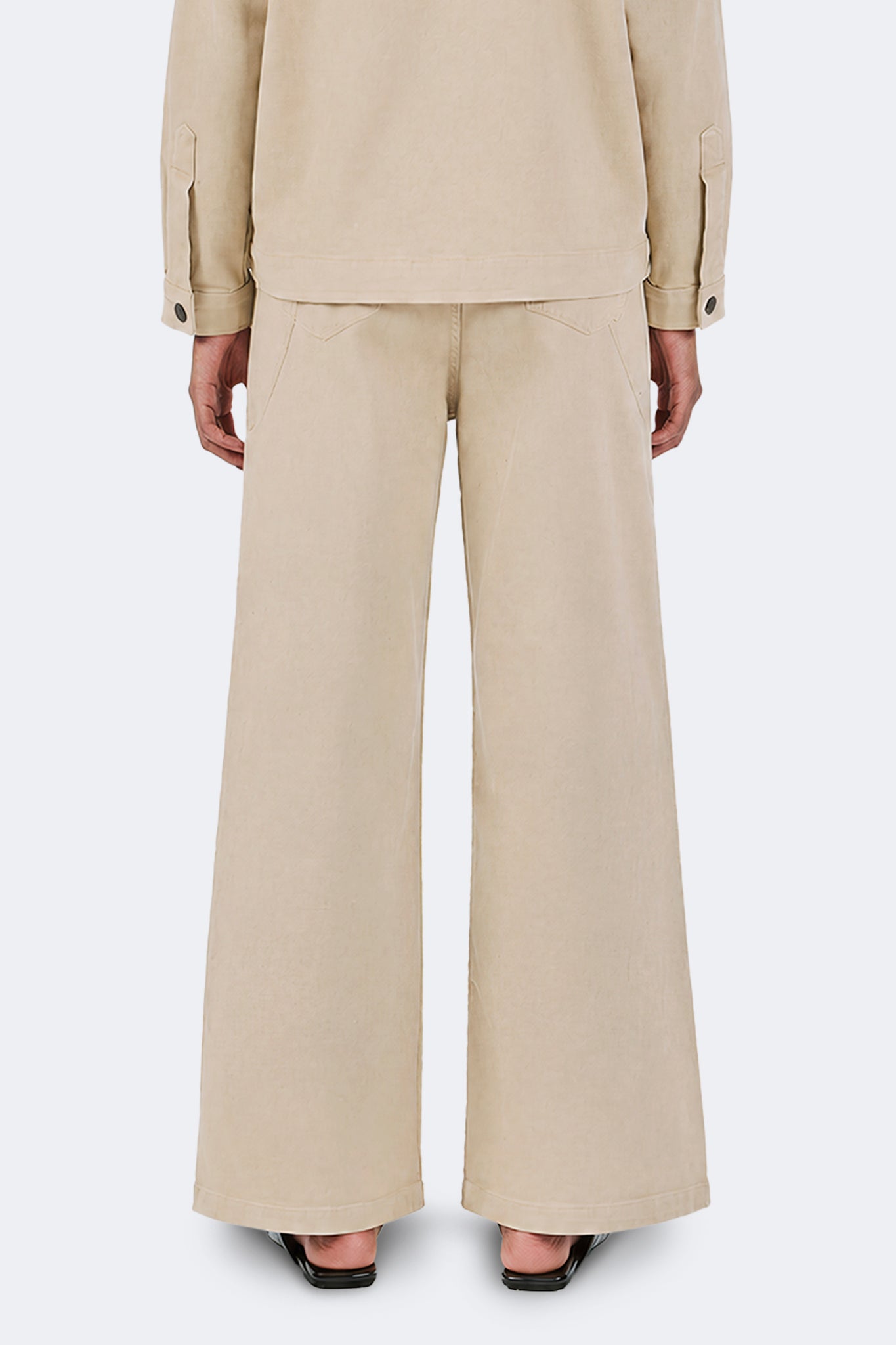 Back detail of the Payla Jeans in Cream highlighting the elongated wide-leg fit, structured drape, and minimalist rear construction in soft cotton denim.