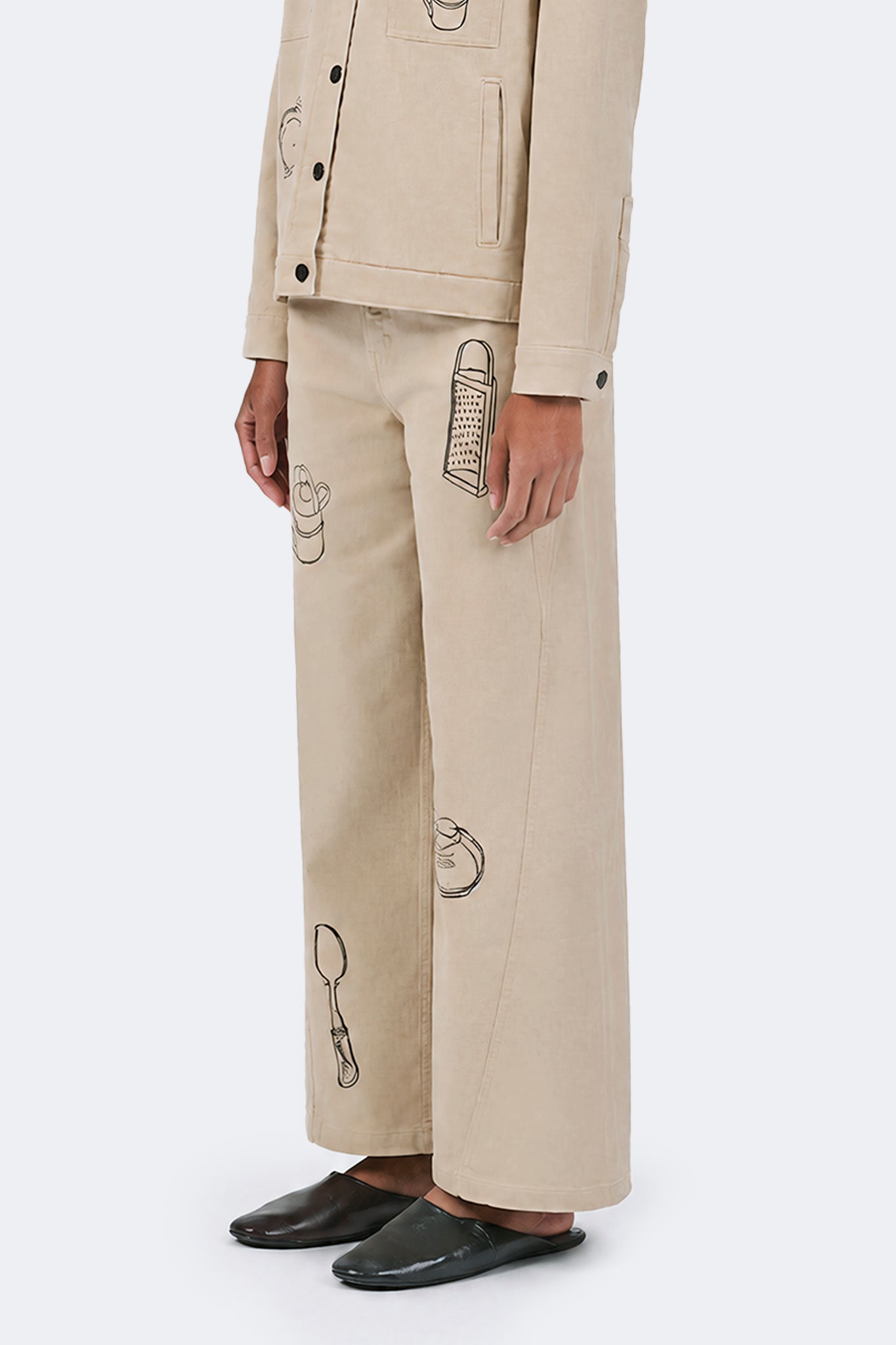 Side detail view of Payla Jeans in Cream highlighting embroidered domestic object motifs.