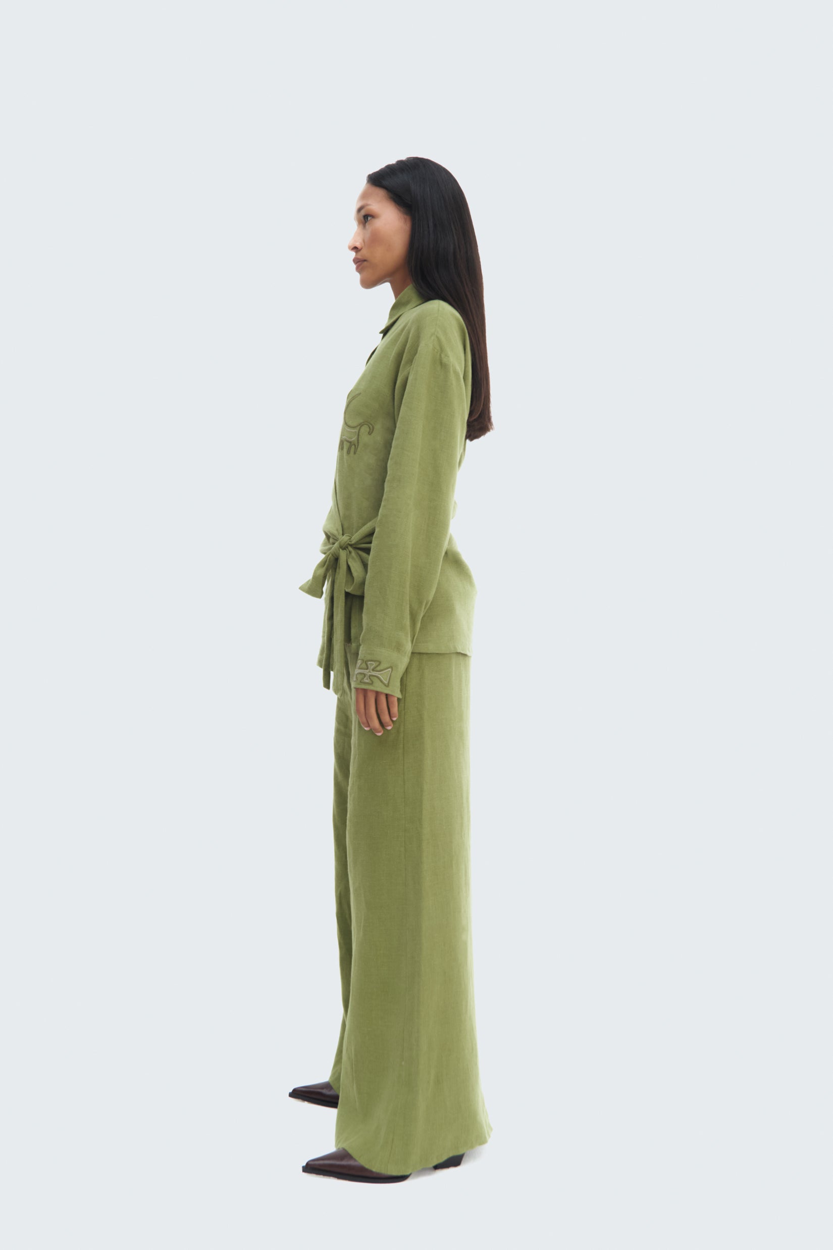 Side view model wearing Pilche Wrapped Blouse by Olga Fisch – linen wrap top with embroidered details