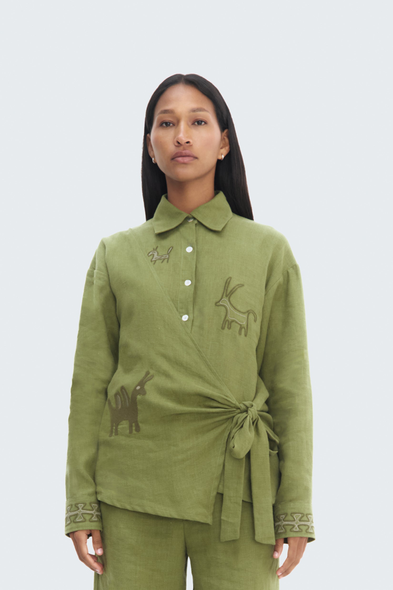 Model wearing Pilche Wrapped Blouse by Olga Fisch – linen wrap top with embroidered details