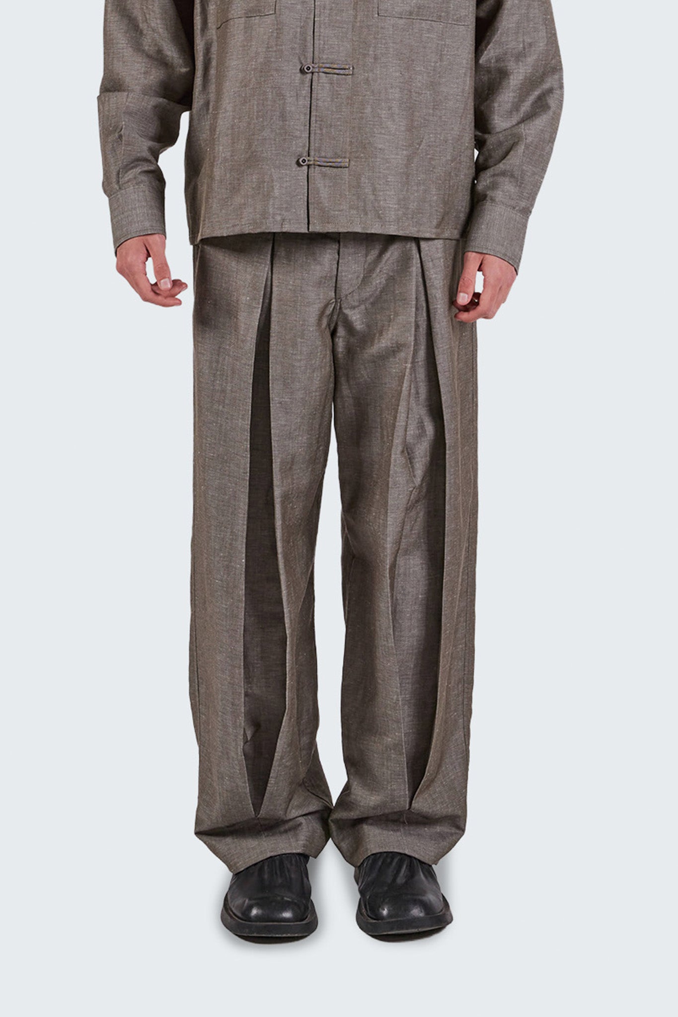Close-up front detail of grey Pita Double Pleated Trousers showing deep pleat construction.