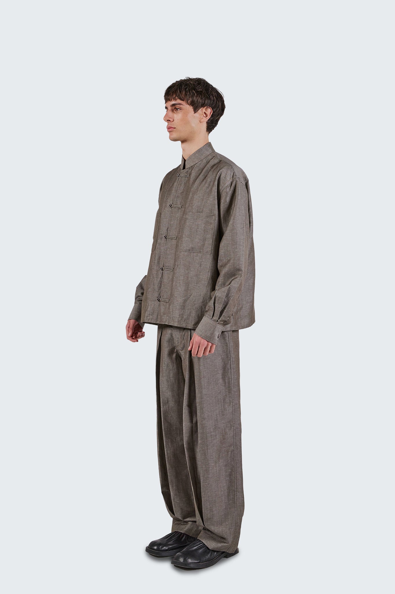 Side profile of the Pita Mao Collared Shirt featuring a Mao collar, relaxed fit, and fluid wool-linen construction.