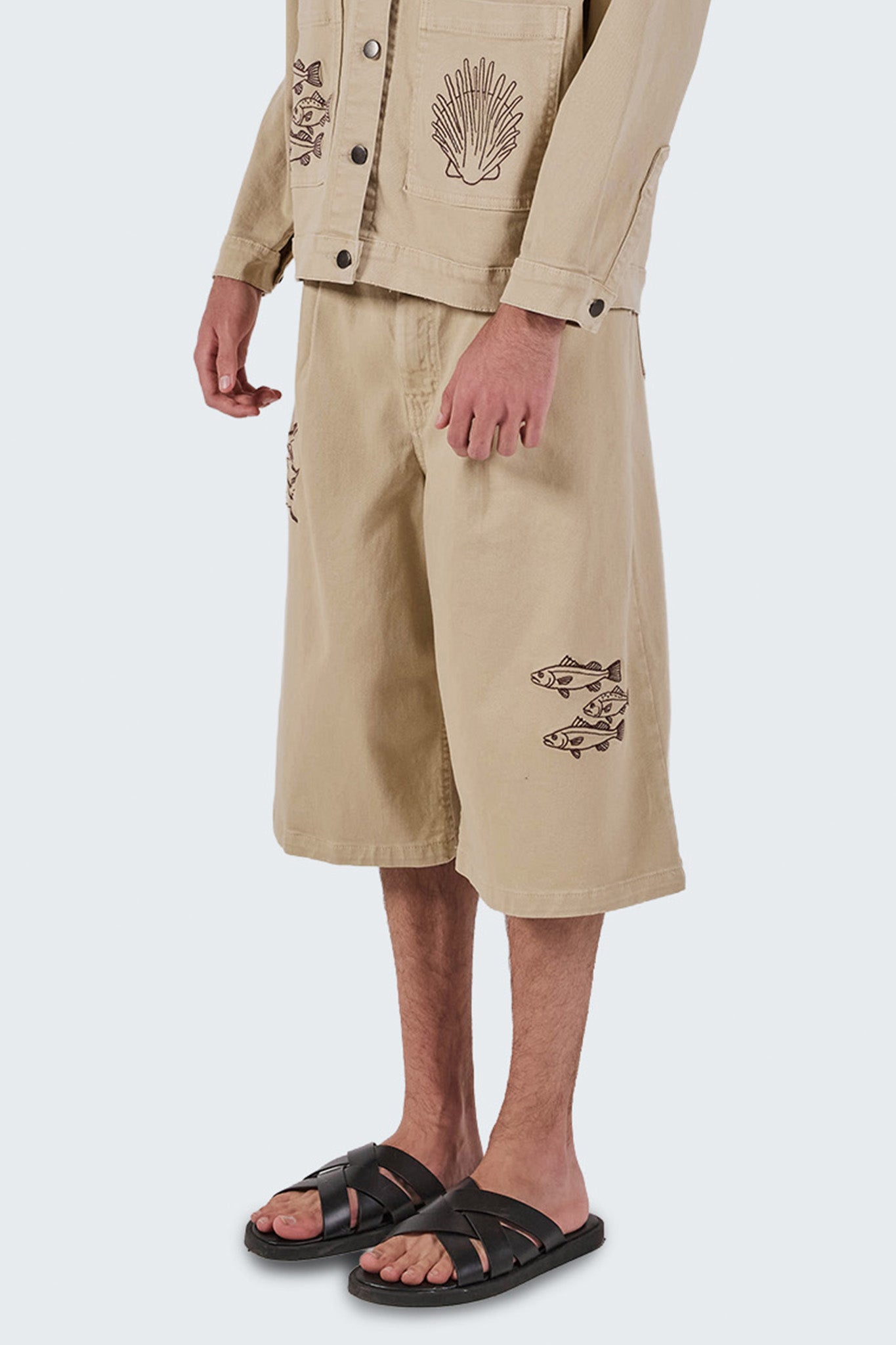 Close-up of Salango Jorts showing embroidered fish artwork, cotton texture, and wide-leg construction.