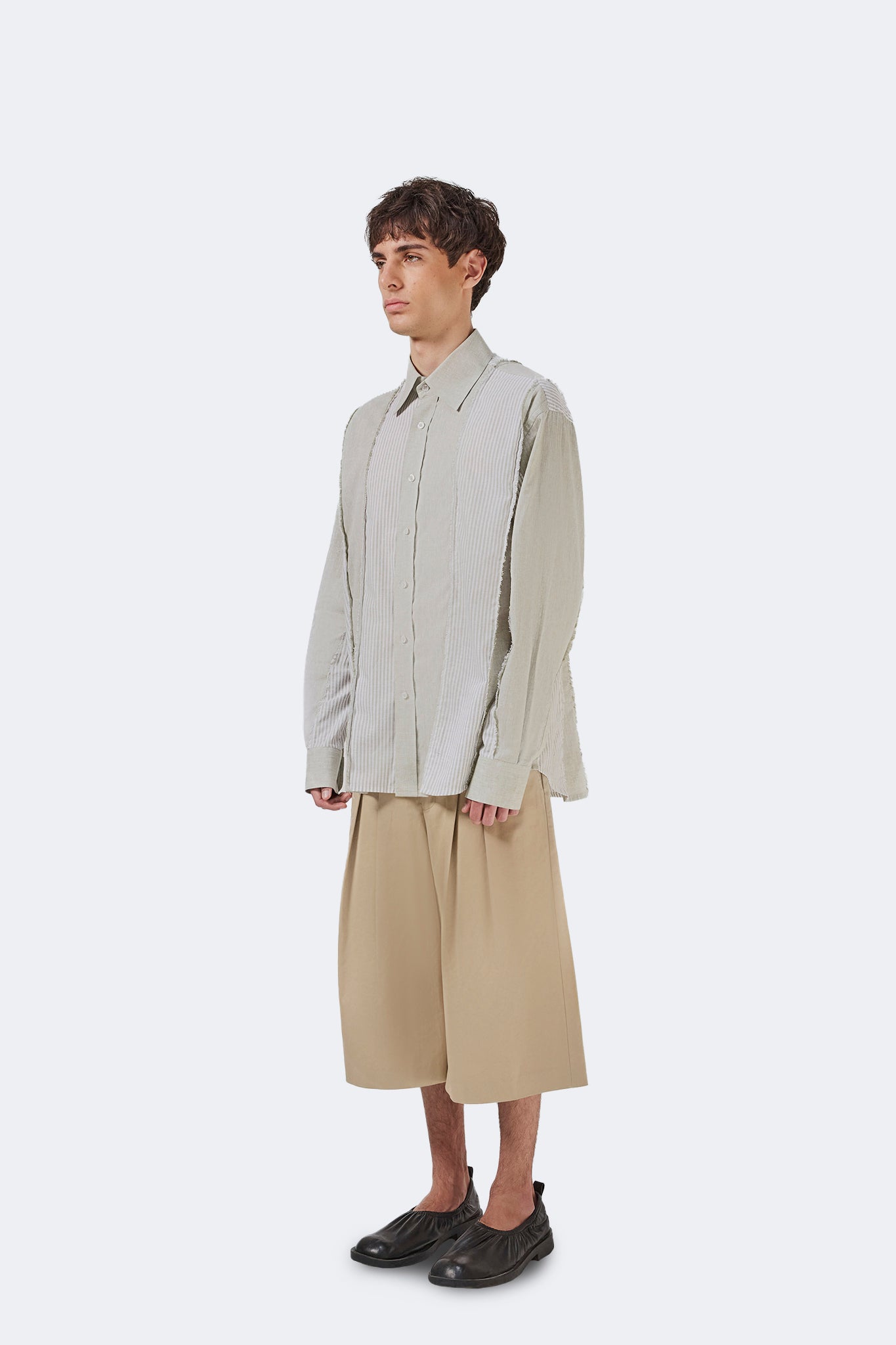 Side detail of the Salango Striped Shirt in Baby Moss highlighting the exposed raw-edge seams, lightweight cotton fabric, and relaxed profile.