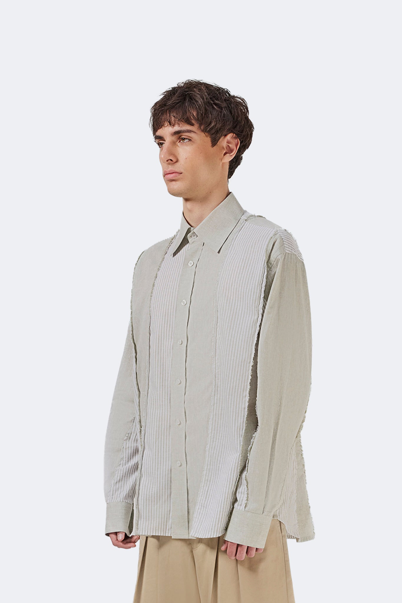 Side detail of the Salango Striped Shirt in Baby Moss highlighting the exposed raw-edge seams, lightweight cotton fabric, and relaxed profile.