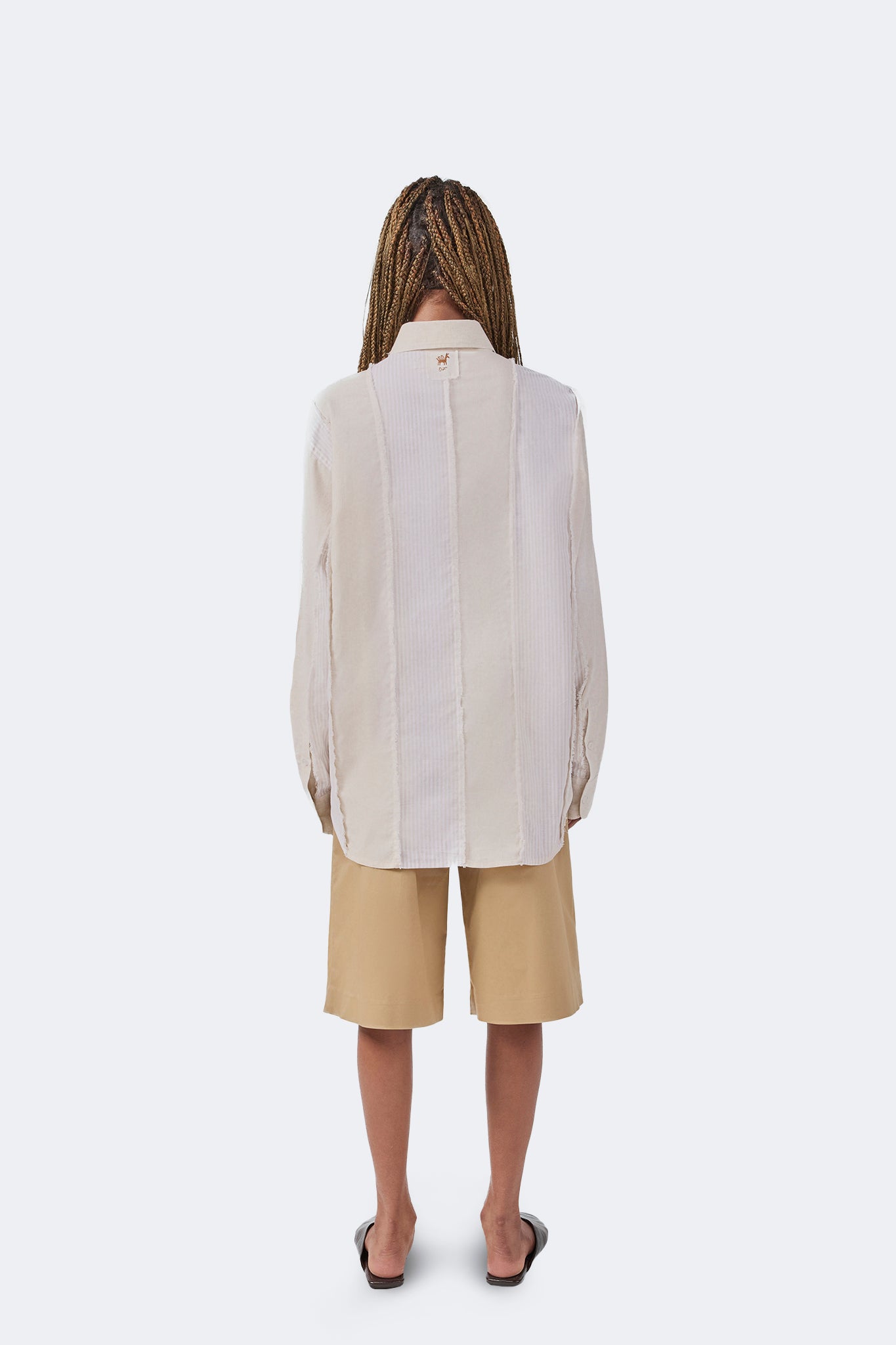 Back view of the Salango Striped Shirt in Sand featuring relaxed tailoring, contrasting striped panels, exposed raw-edge detailing, and curved hem.