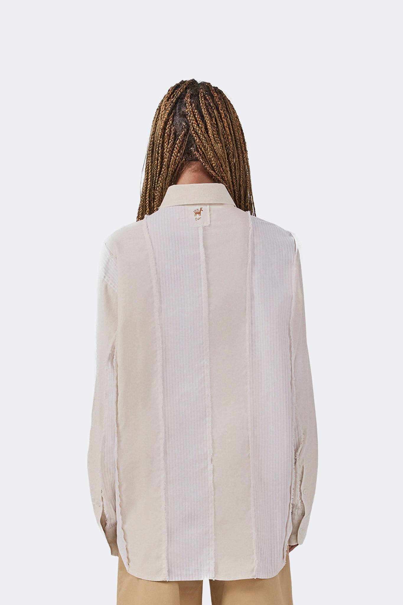 Back detail of the Salango Striped Shirt in Sand featuring tonal striped panels, exposed raw-edge seams, signature Olga Fisch label, and classic point collar.