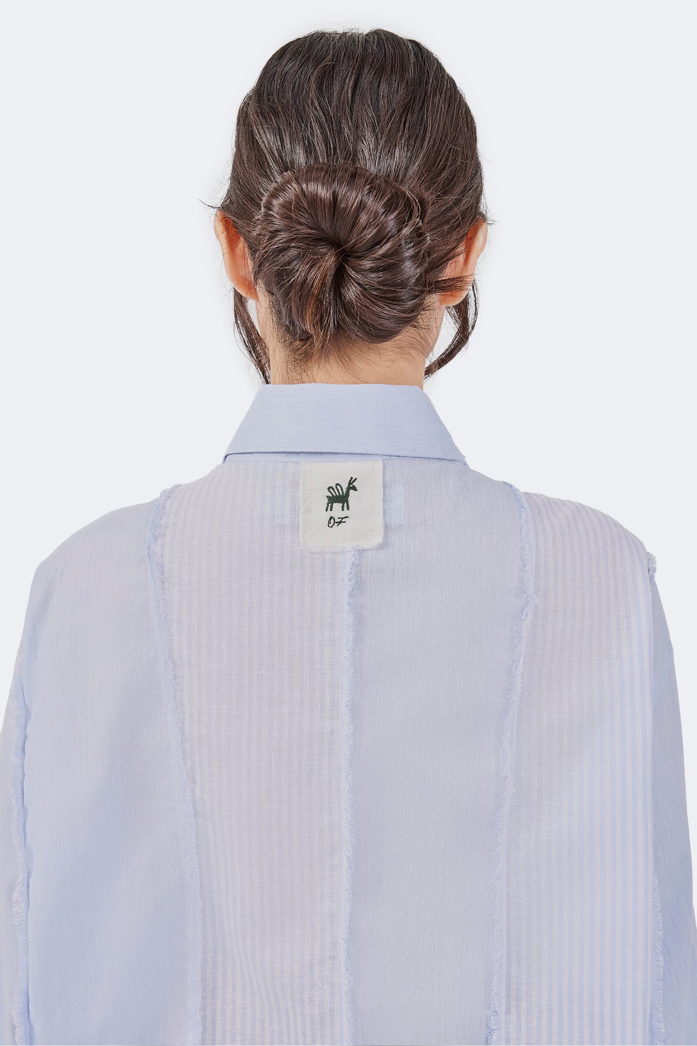 Back detail of the Salango Striped Shirt in Sky featuring tonal striped panels, exposed raw-edge seams, signature Olga Fisch label, and classic point collar.