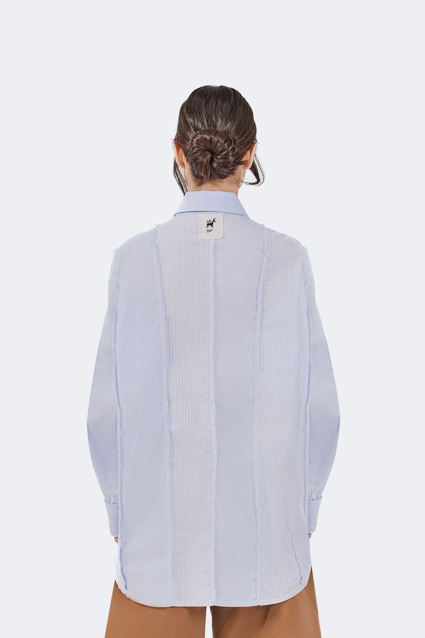 Back detail of the Salango Striped Shirt in Sky featuring tonal striped panels, exposed raw-edge seams, signature Olga Fisch label, and classic point collar.