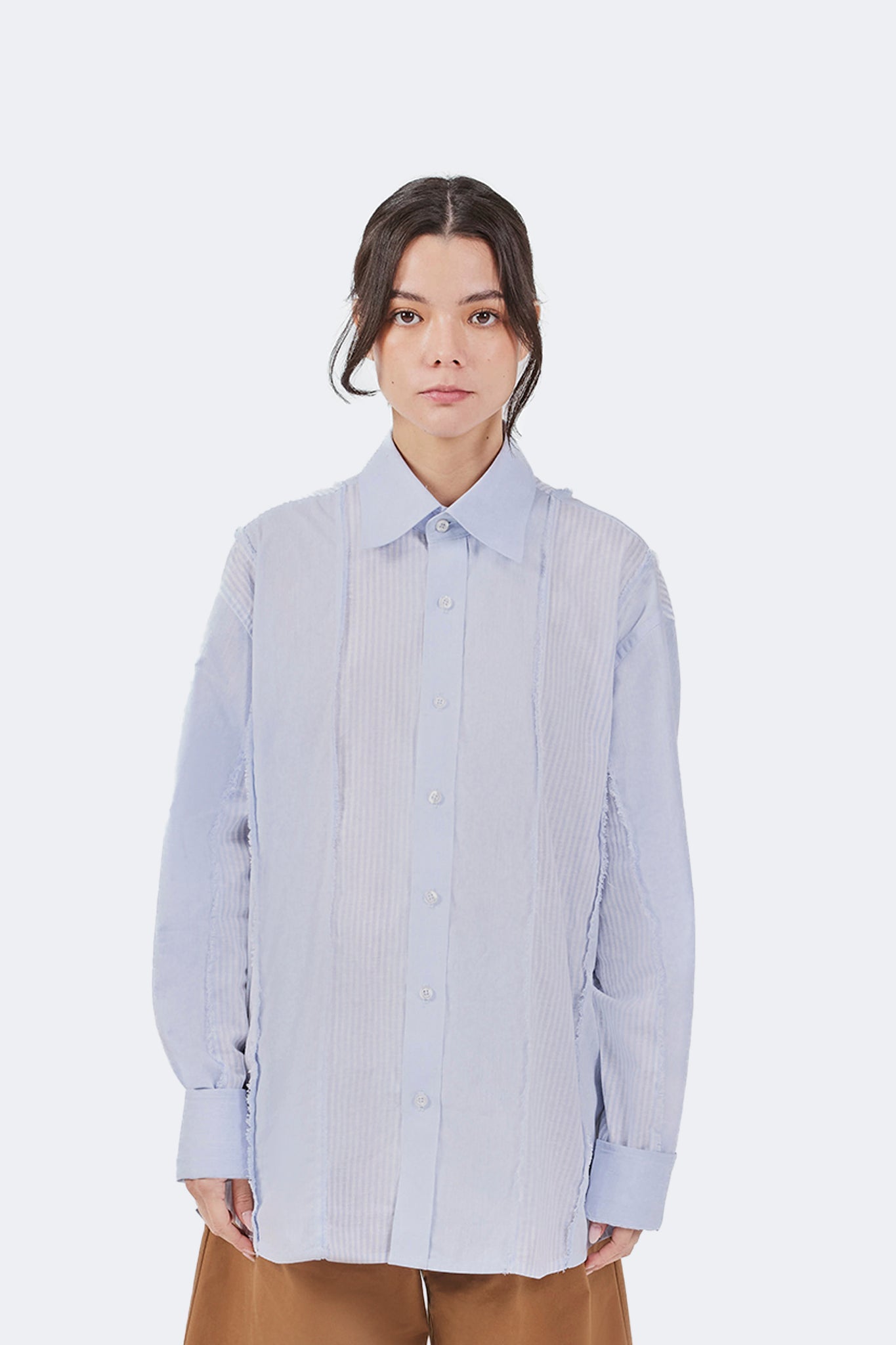 Front detail of the Salango Striped Shirt in Sky crafted from lightweight 100% cotton with tonal striped panels, exposed raw-edge seams, classic point collar, and button-front closure.