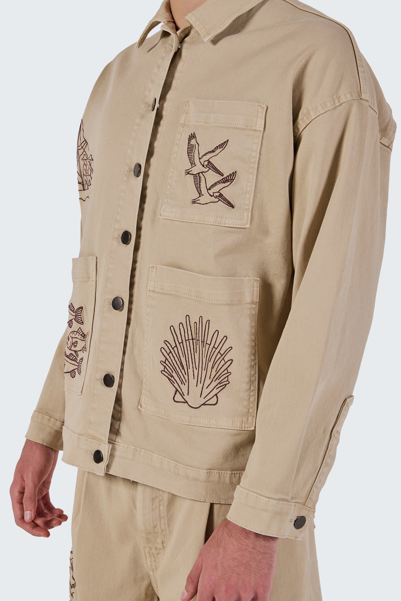 Detailed view of the Salango Workman Jacket featuring embroidered marine-inspired artwork and patch pockets.