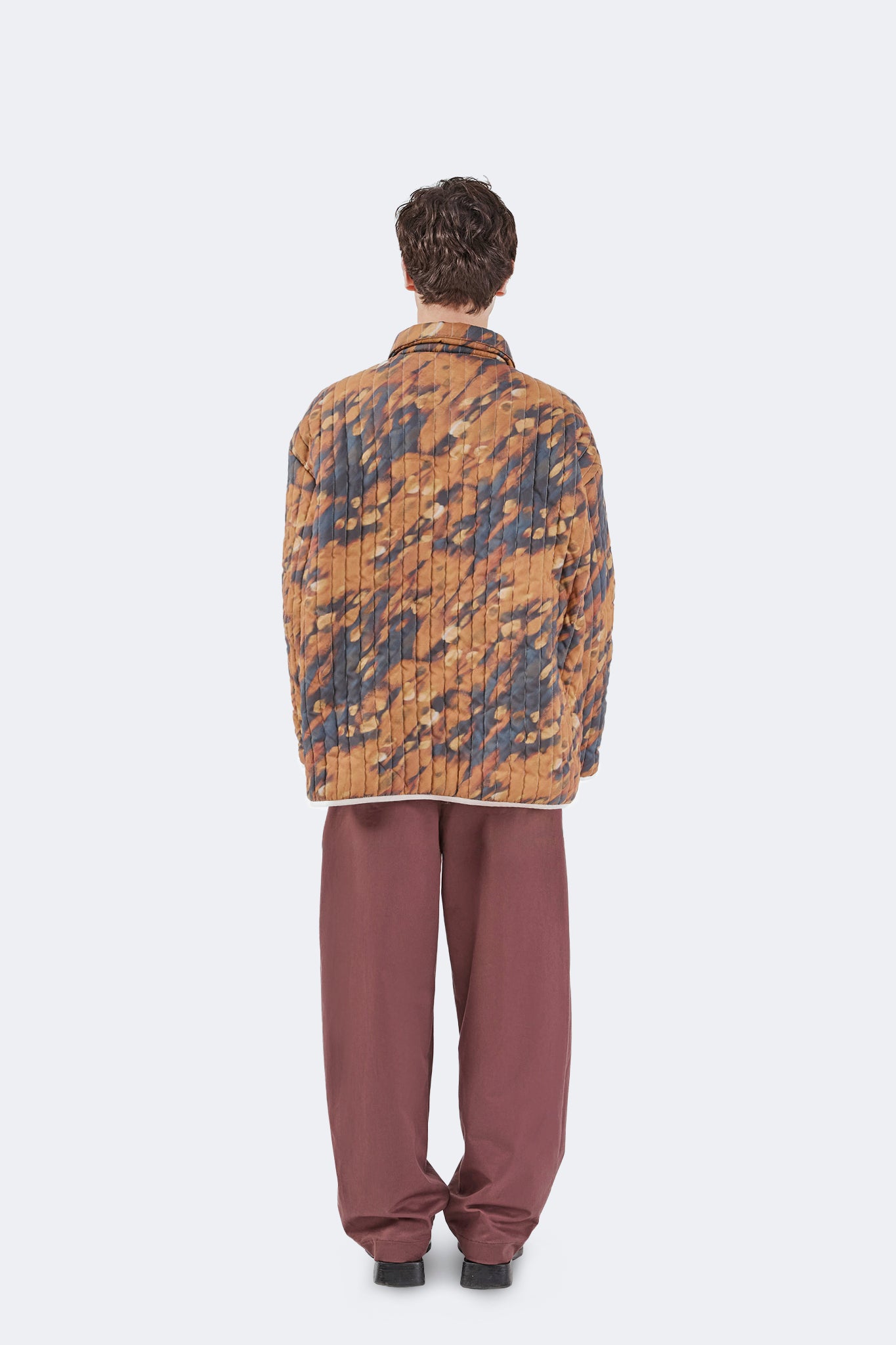Full back view of the Same Quilted Jacket highlighting the continuous Same print, relaxed silhouette, and vertical quilted stitching.