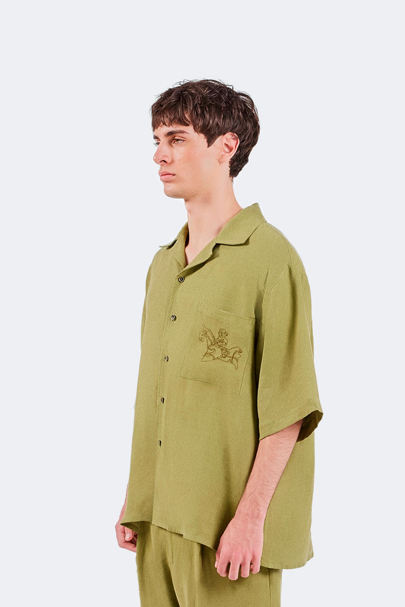 Close-up side detail of the San Cristobal Short-Sleeved Shirt showcasing the embroidered equestrian motif and textured linen fabric.