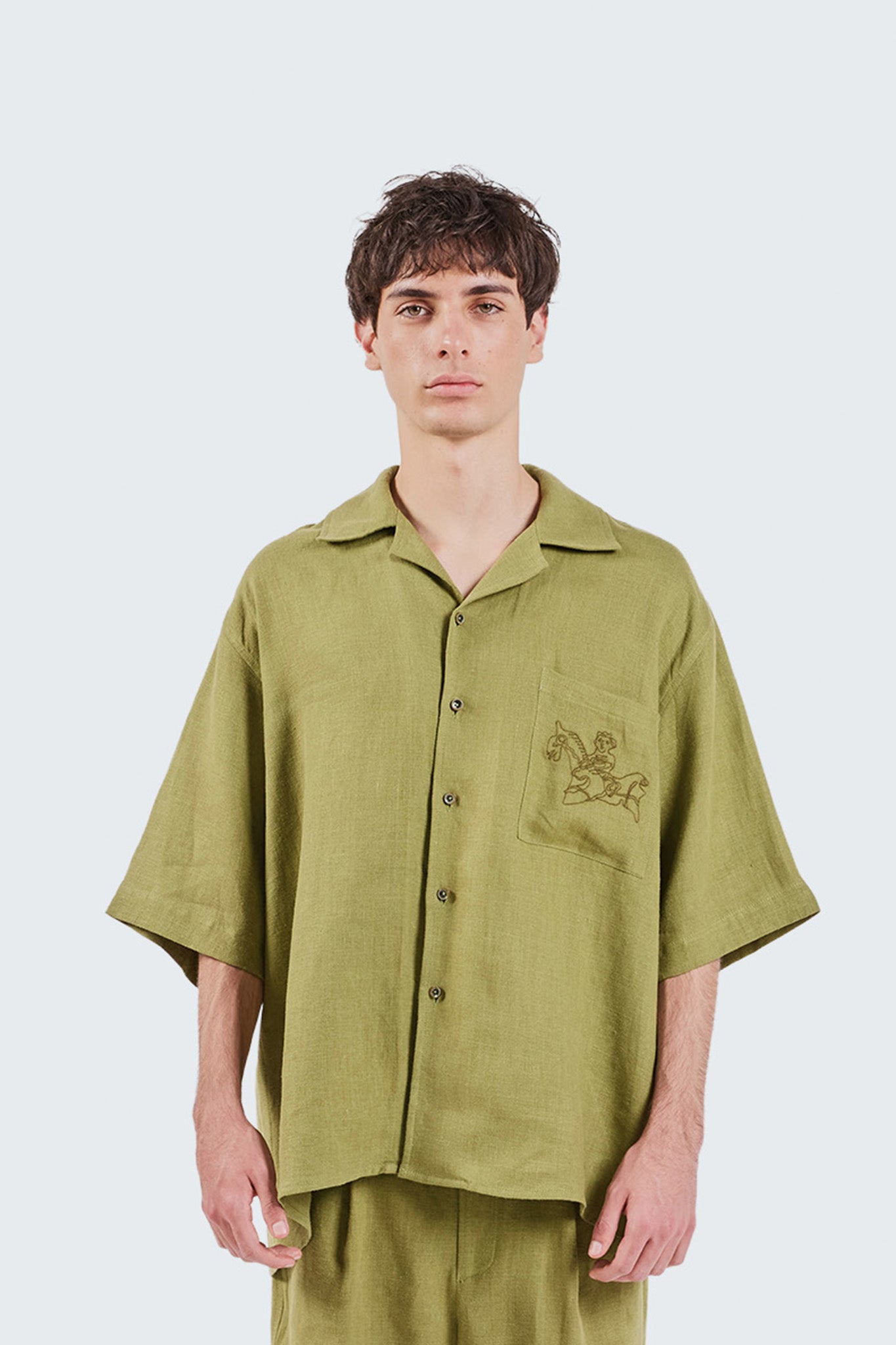 Portrait view of the San Cristobal Short-Sleeved Shirt featuring an oversized silhouette, camp collar, and Moss linen fabrication.