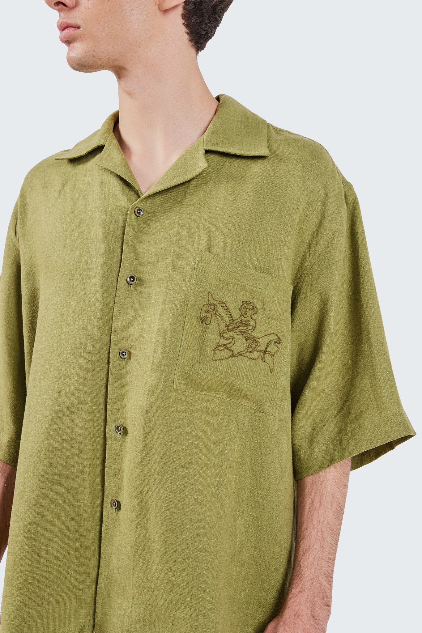 Close-up front detail of the San Cristobal Short-Sleeved Shirt highlighting the embroidered chest pocket and premium linen construction.