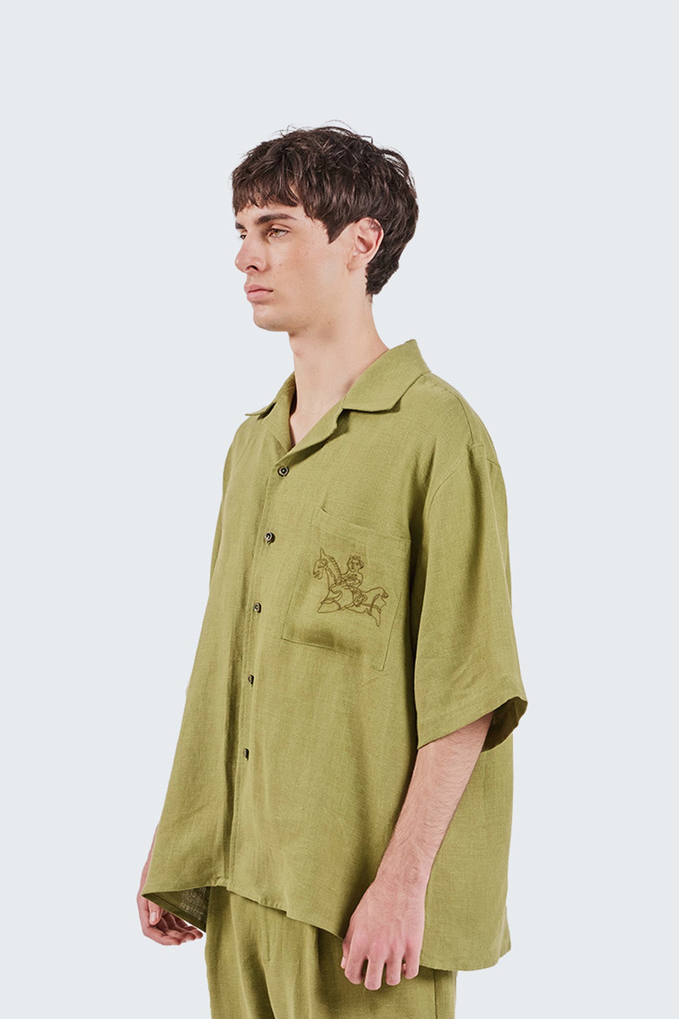 Close-up side detail of the San Cristobal Short-Sleeved Shirt showcasing the embroidered equestrian motif and textured linen fabric.