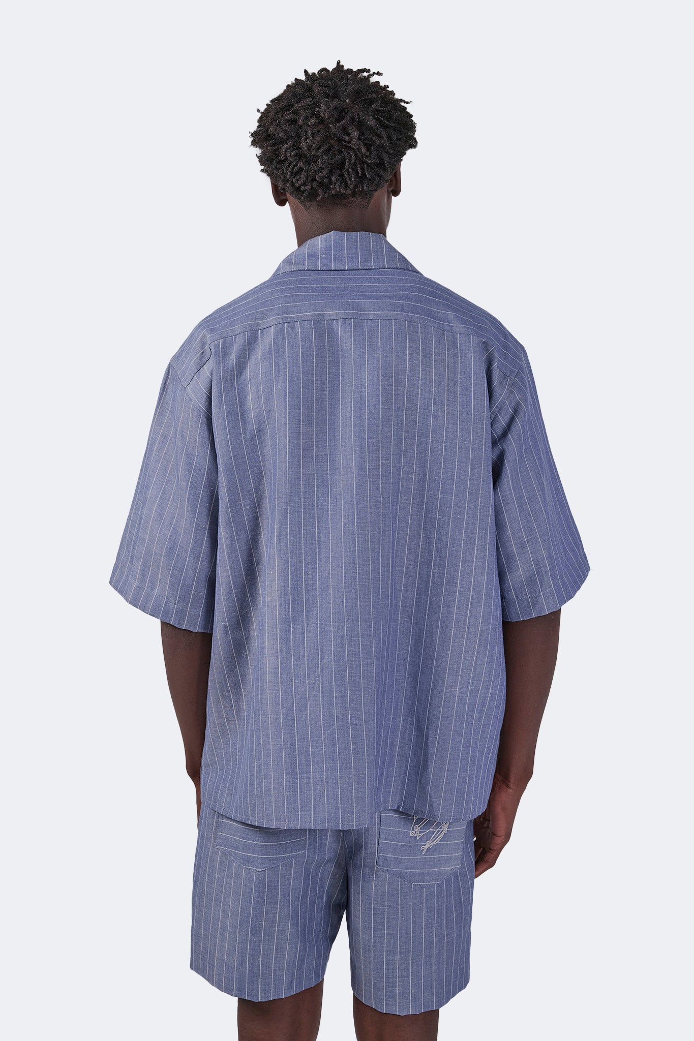 Back detail of the Santa Cruz Short-Sleeved Shirt in Indigo Pinstripe featuring the relaxed oversized silhouette, vertical pinstripe linen, and clean yoke construction.