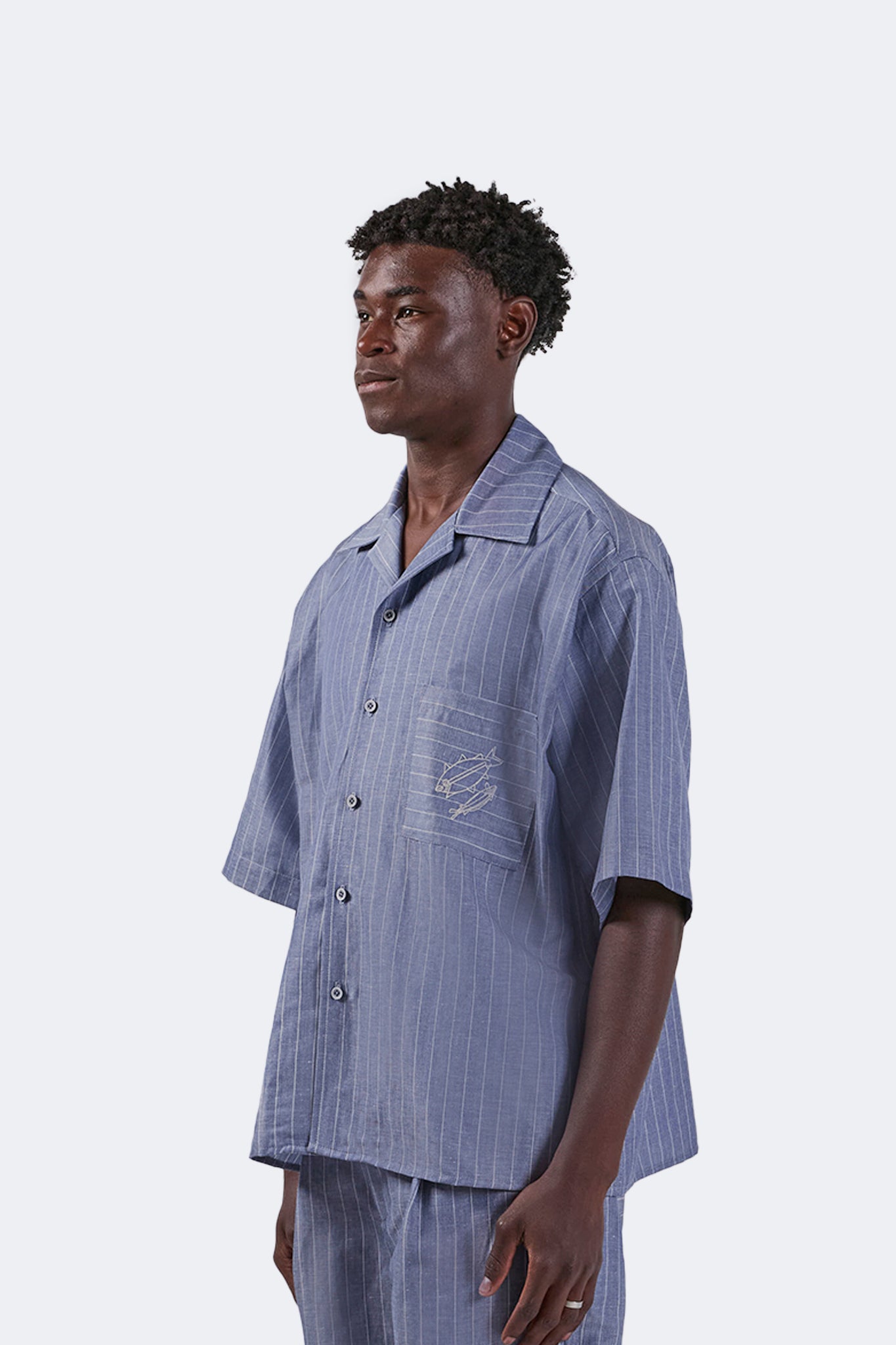 Side detail of the Santa Cruz Short-Sleeved Shirt in Indigo Pinstripe showcasing the relaxed fit, lightweight linen construction, and fluid drape.