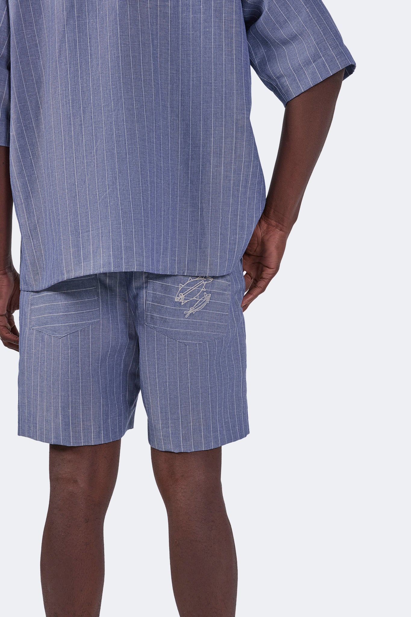 Back detail of the Santa Cruz Linen Shorts Indigo highlighting the embroidered back pocket, natural linen texture, and relaxed fit.