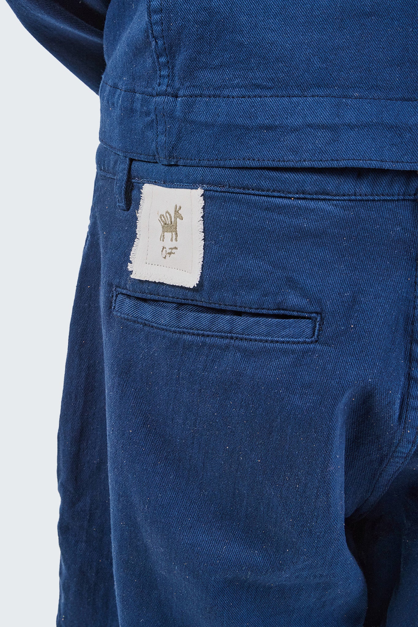 Close-up of blue pants with a brand label on a white background